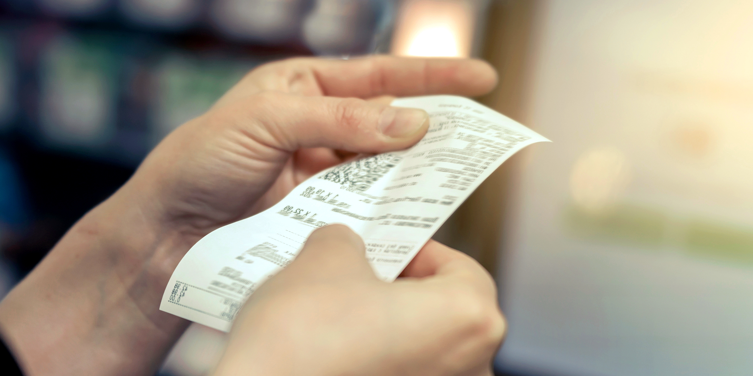 Femme tenant un ticket de caisse d'épicerie | Source : Shutterstock