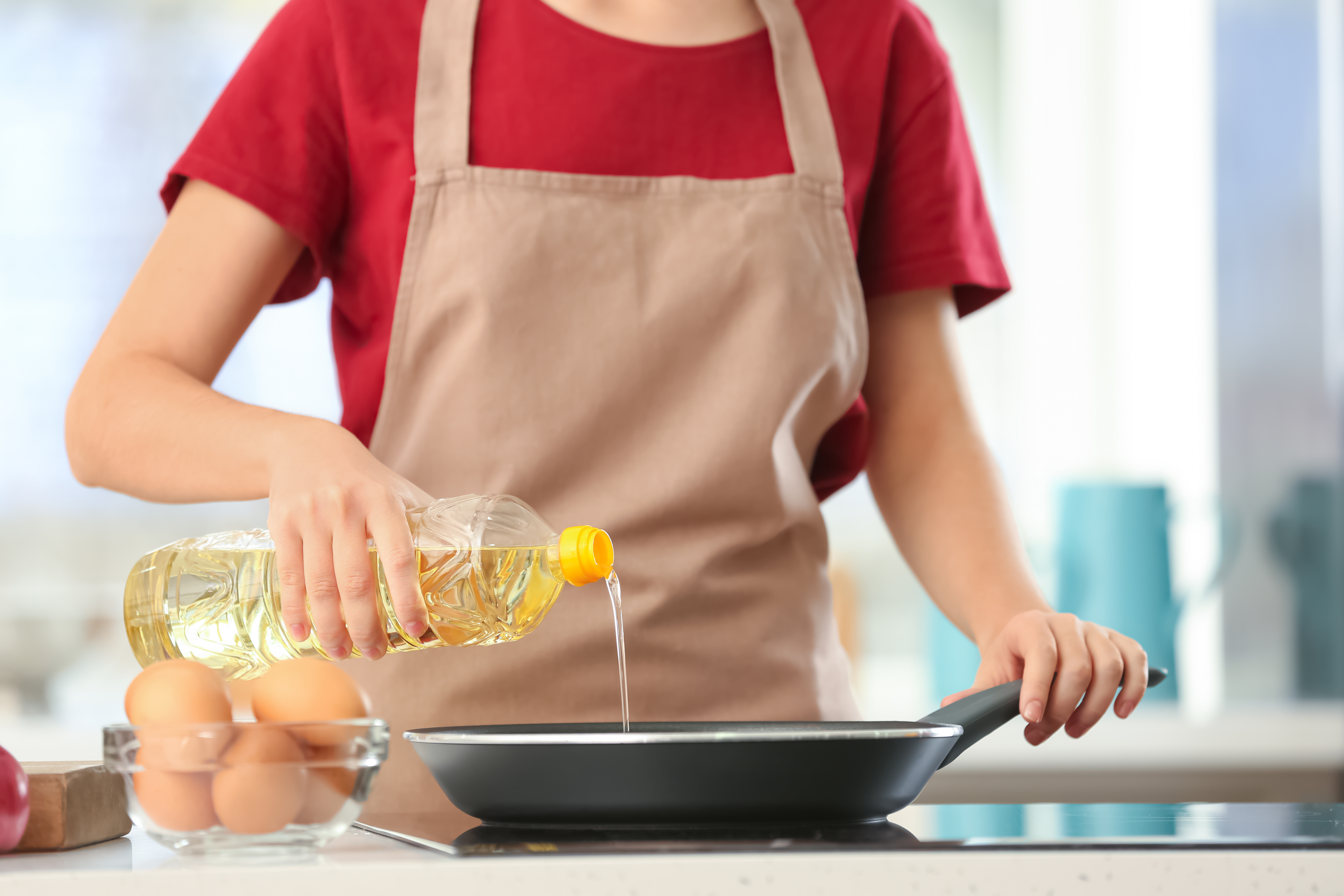 Quelqu'un qui verse de l'huile végétale dans une casserole | Source : Shutterstock