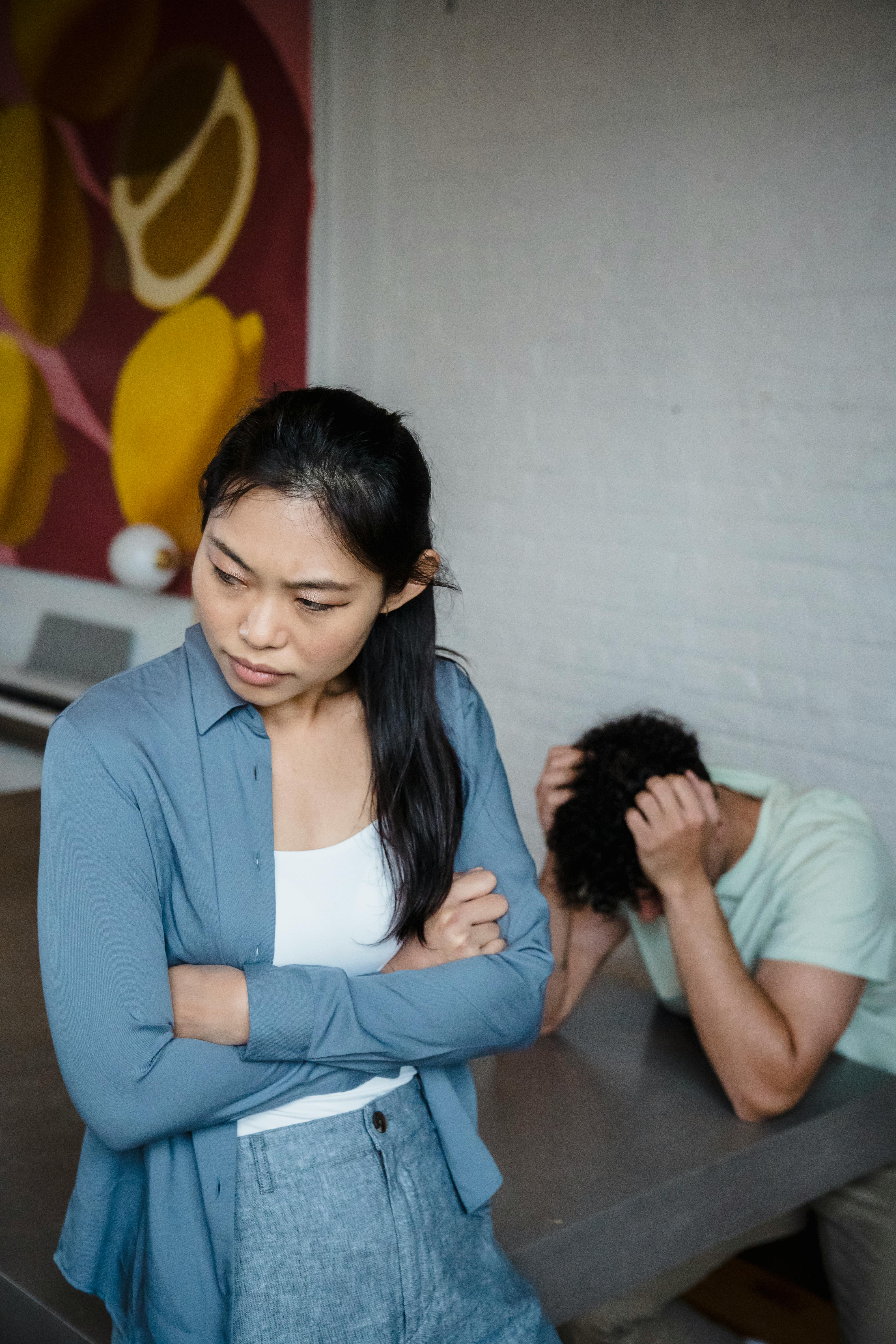 Une femme et un homme enfouissant sa tête dans ses mains | Source : Pexels