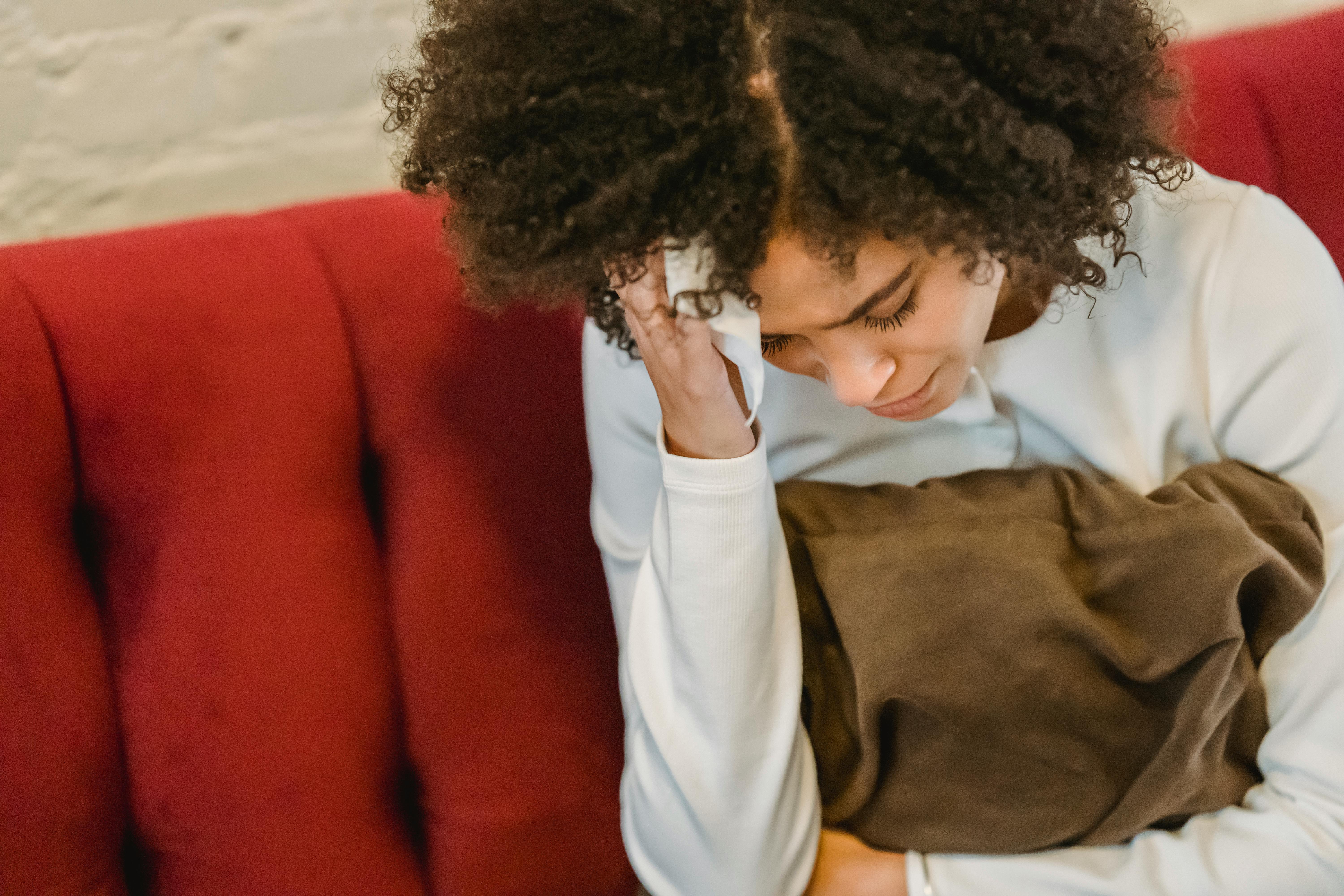 Une femme triste assise sur le canapé | Source : Pexels