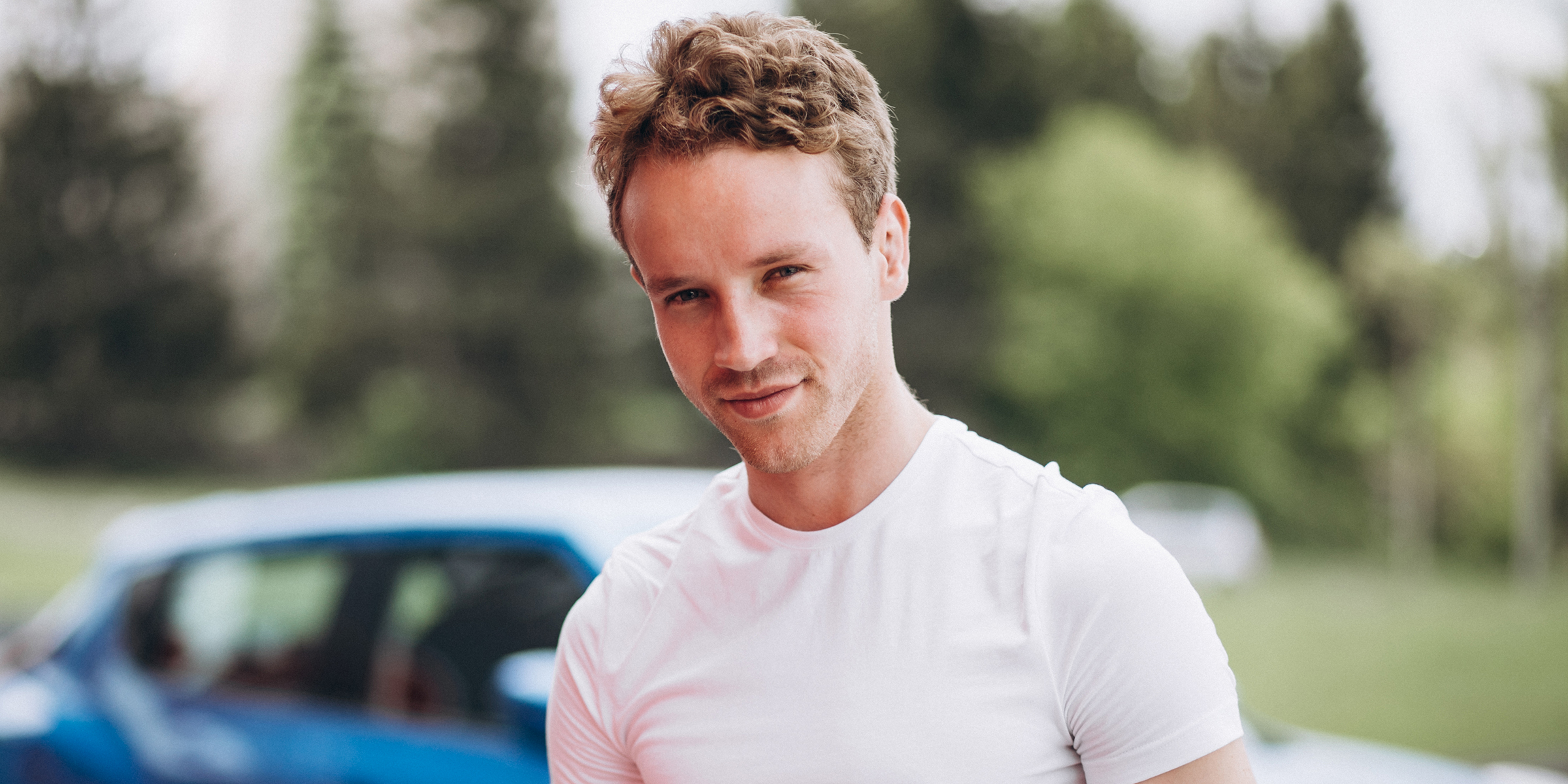 Un jeune homme debout devant une voiture | Source : Freepik