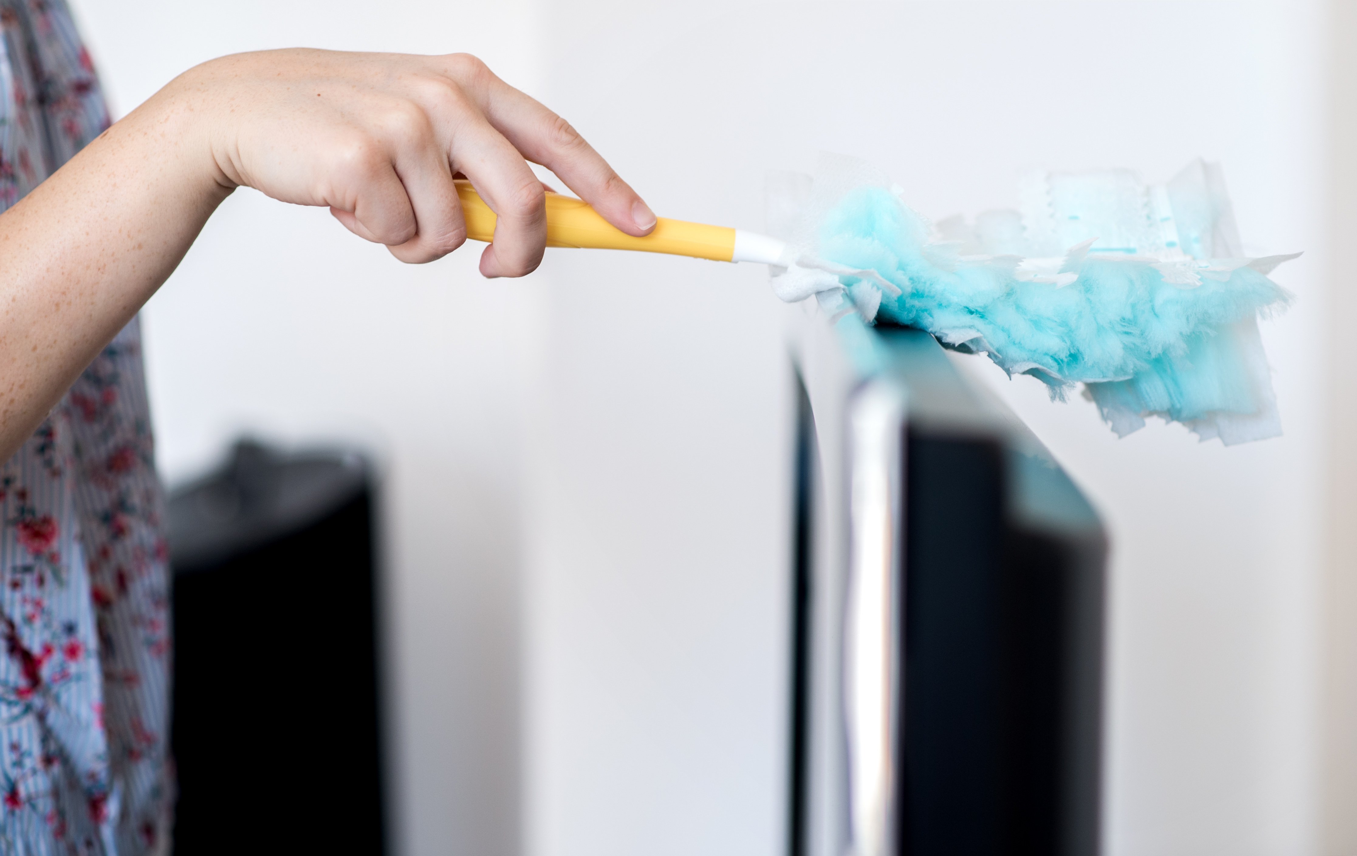 Une femme nettoyant son téléviseur avec un plumeau | source: Getty Images