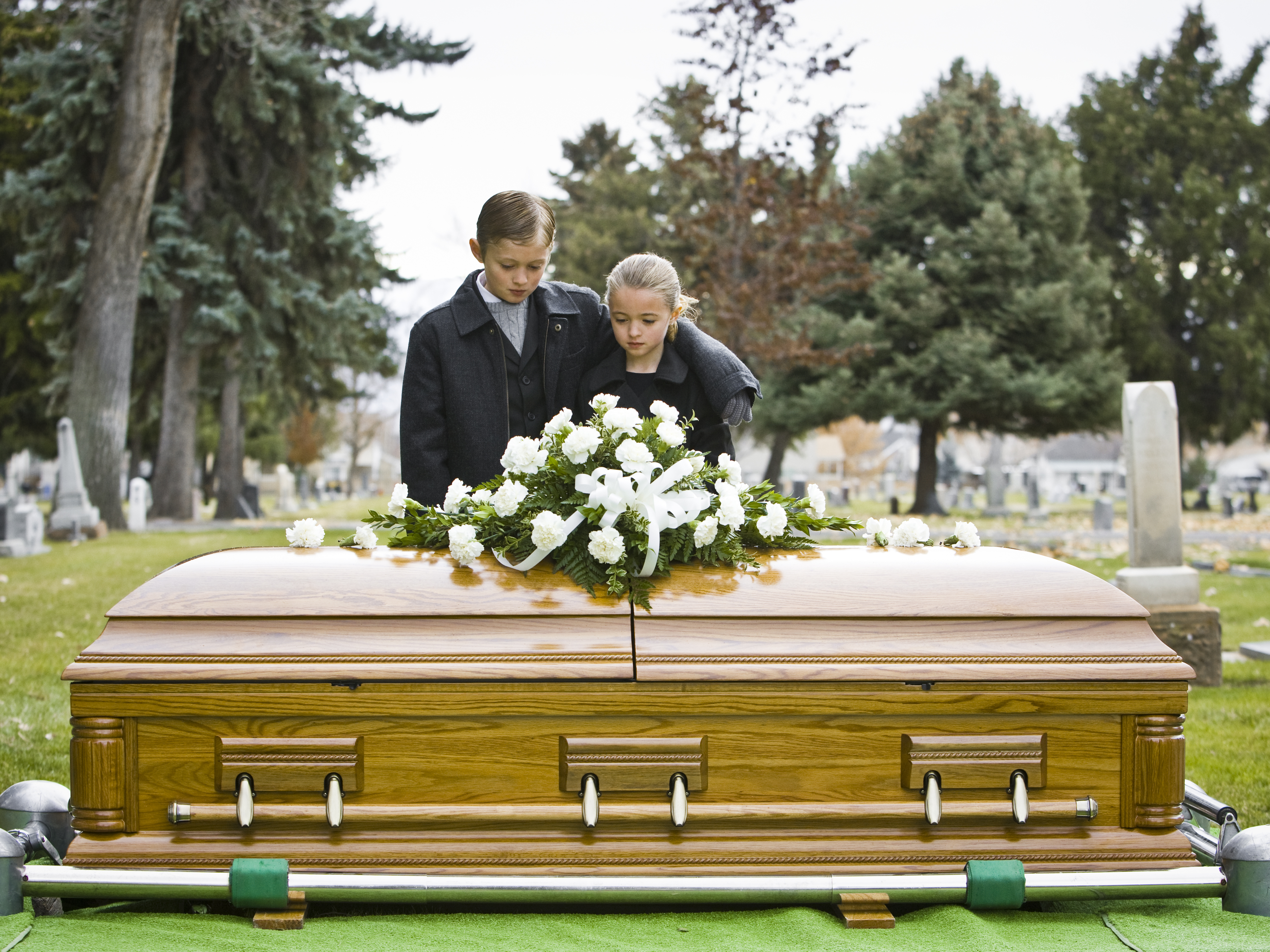 Un frère et une sœur lors d'un enterrement | Source : Getty Images