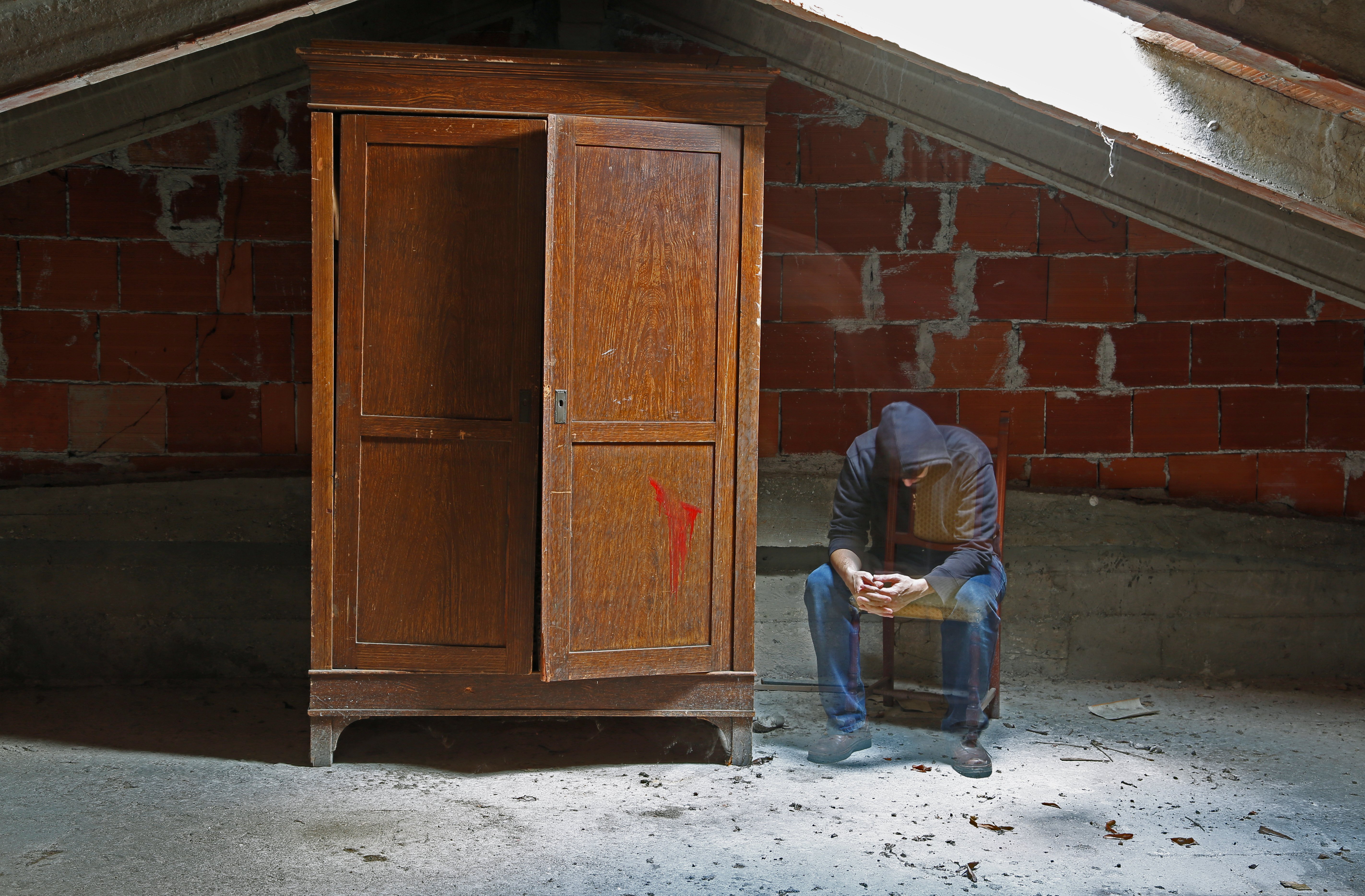 Un homme assis à côté d'un placard. | photo : Shutterstock