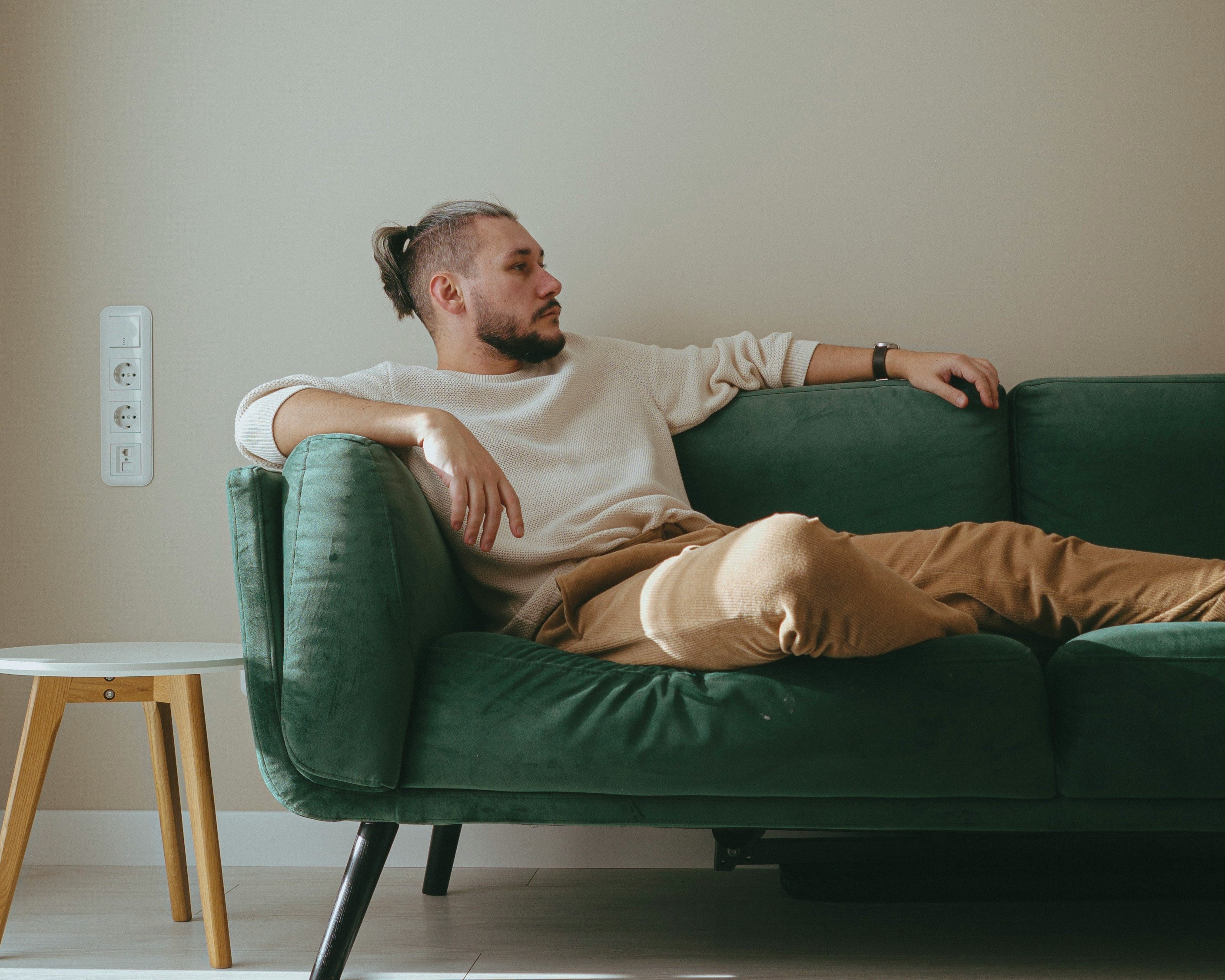 Un homme assis sur un canapé | Source : Unsplash