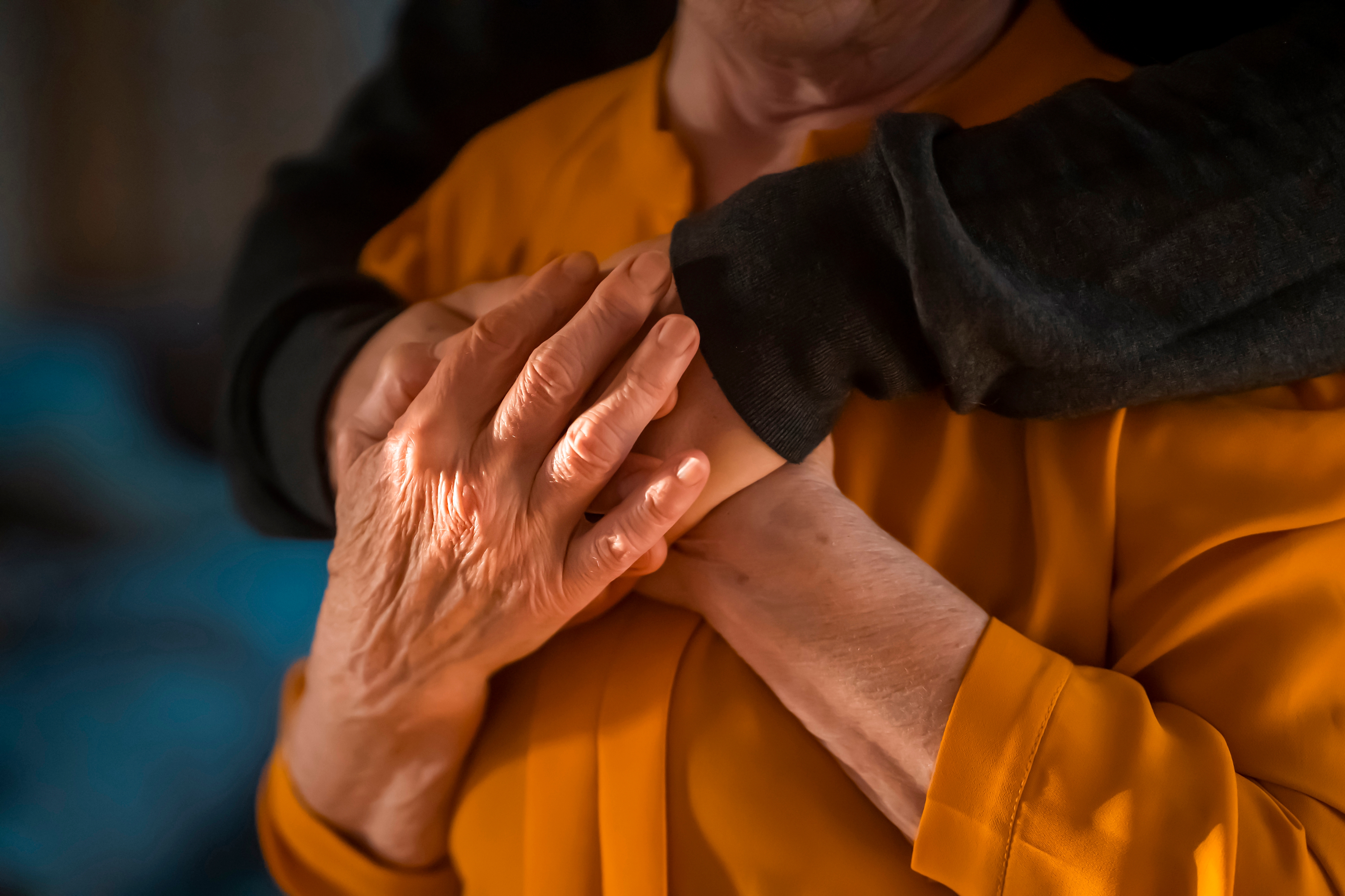 Une maman senior tenant les mains de son fils dans un geste de réconfort et de soutien | Source : Shutterstock