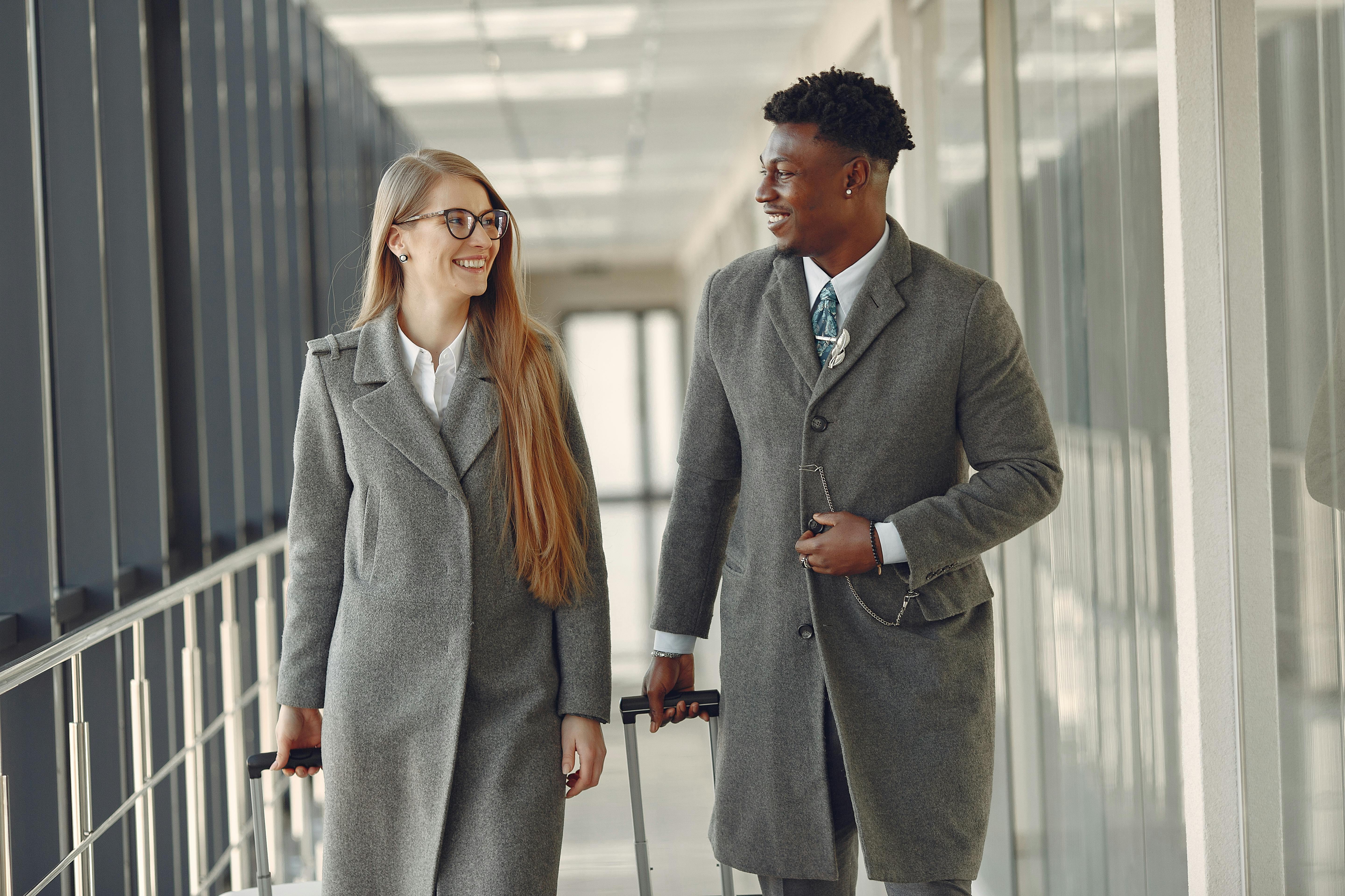 Une femme et un homme en pleine conversation dans une passerelle d'aéroport | Source : Pexels