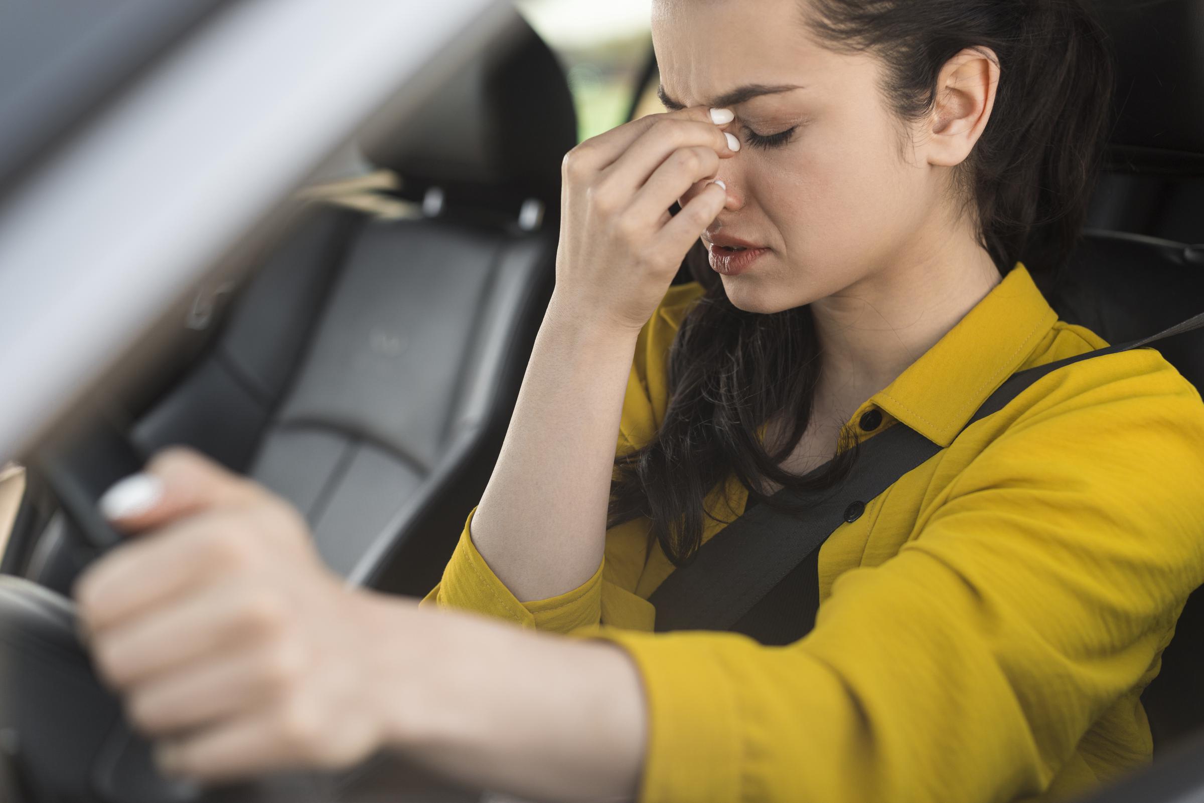 Une femme en détresse au volant d'une voiture | Source : Freepik