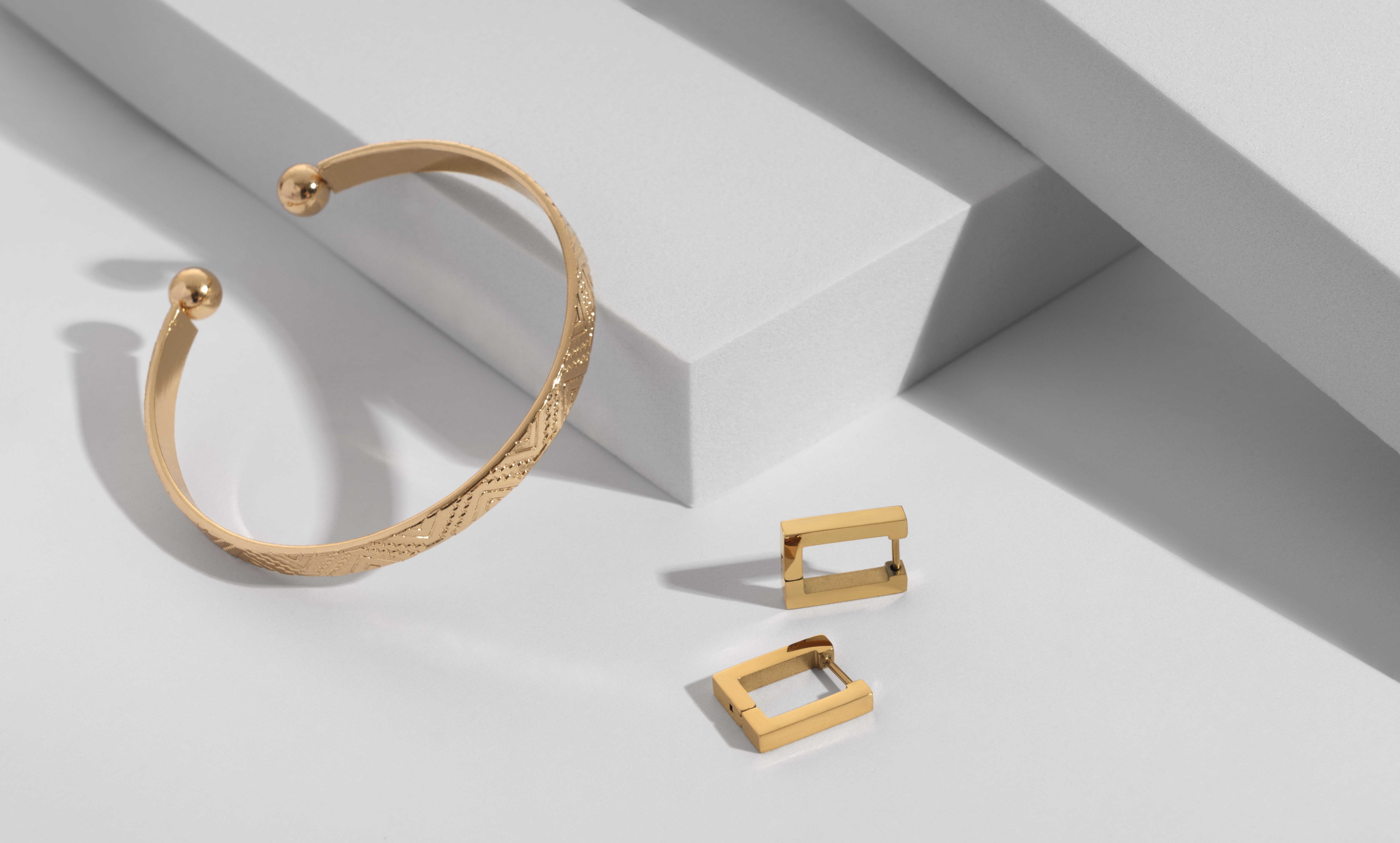 Une paire de boucles d'oreilles en or et un bracelet | Source : Shutterstock