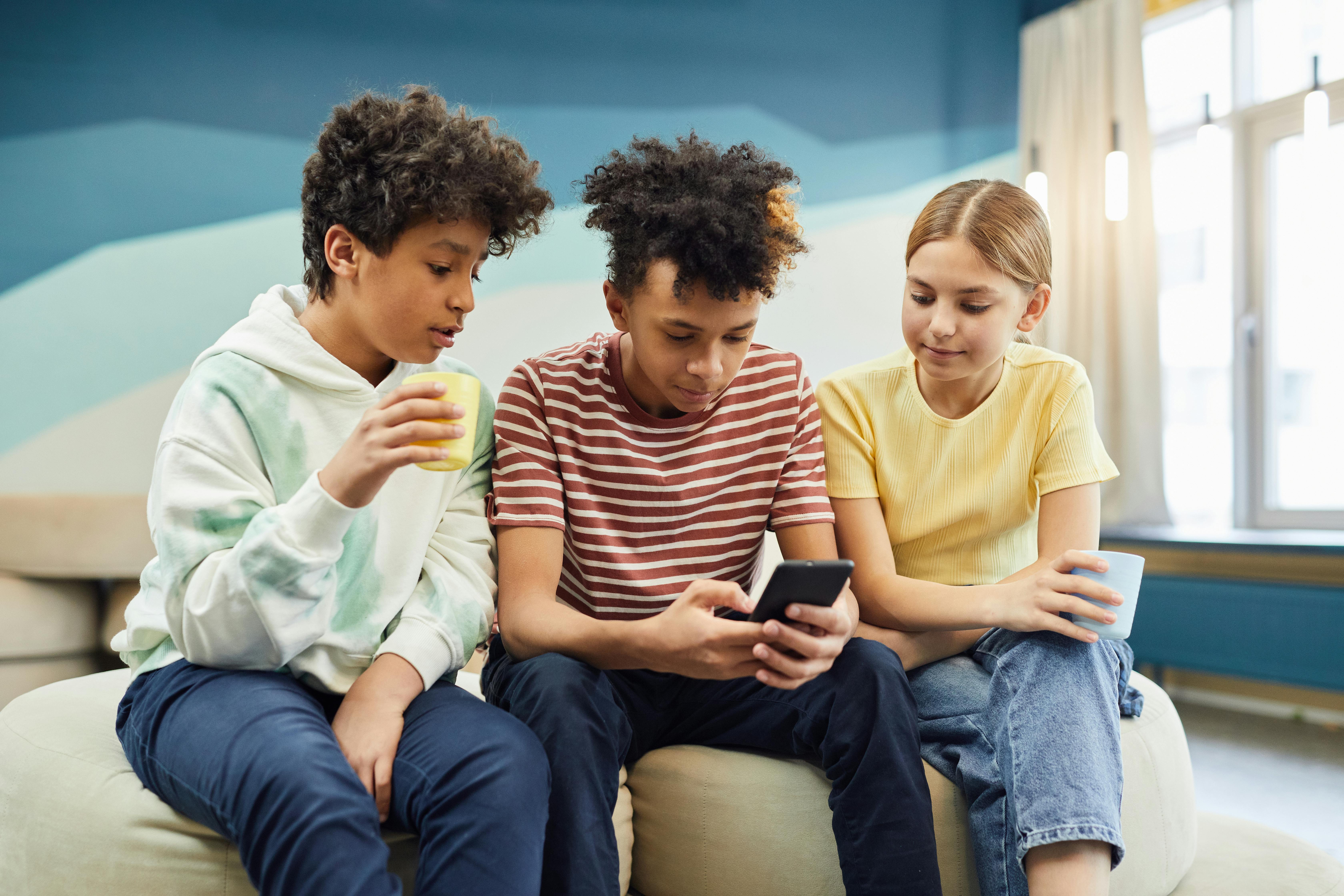 Des enfants rassemblés autour d'un téléphone | Source : Pexels