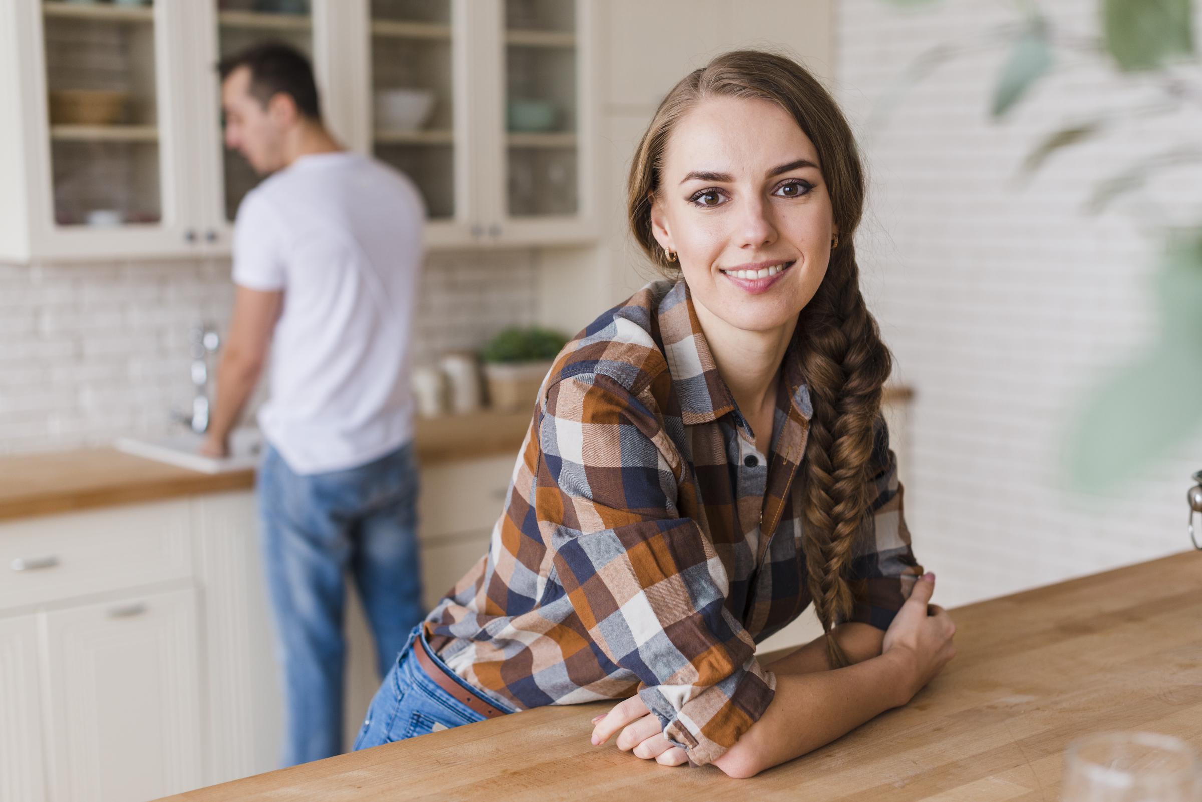 Femme souriante s'appuyant sur la table | Source : Freepik