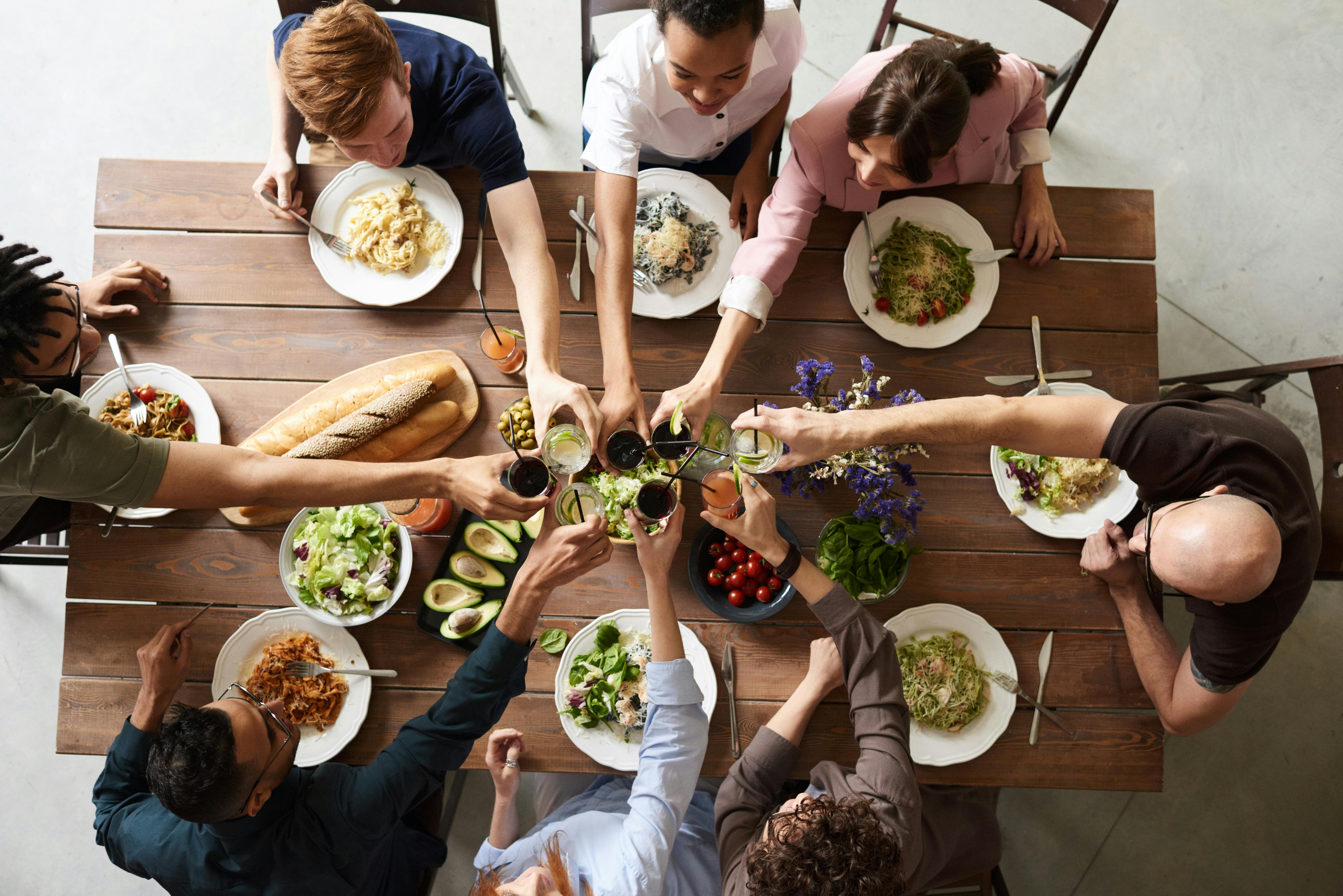 Un groupe de personnes portant un toast pendant un repas | Source : Pexels