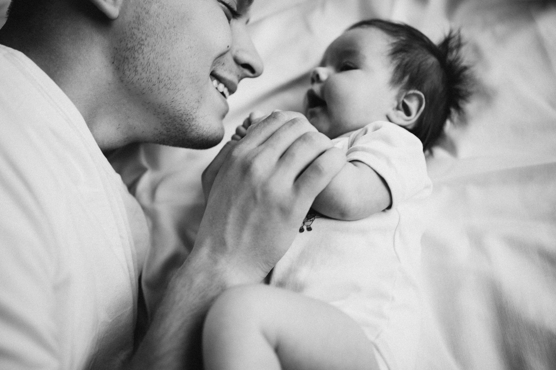 Un père allongé sur son lit avec son nouveau-né | Source : Pexels