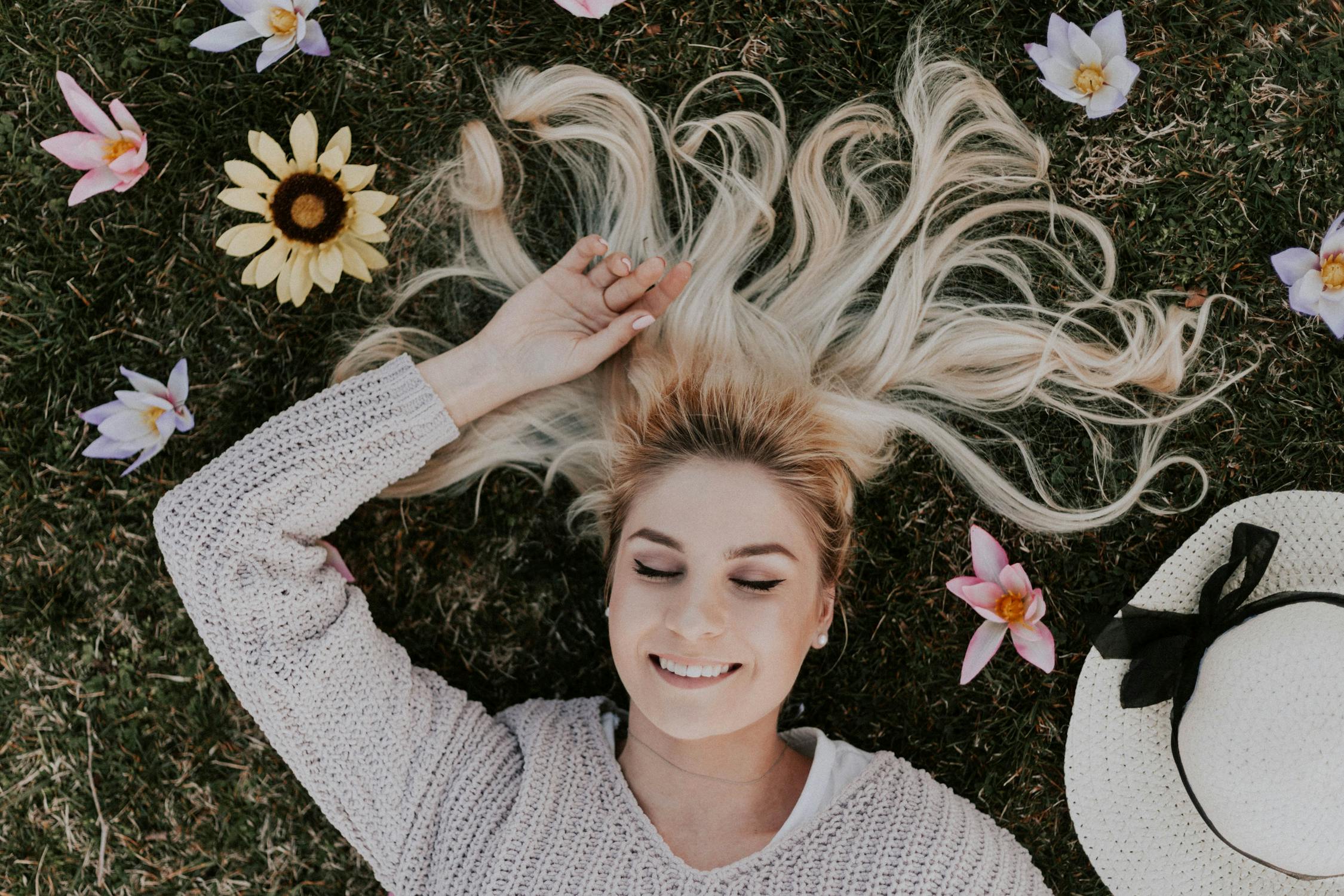 Une femme heureuse allongée sur le sol ⏐ Source : Pexels