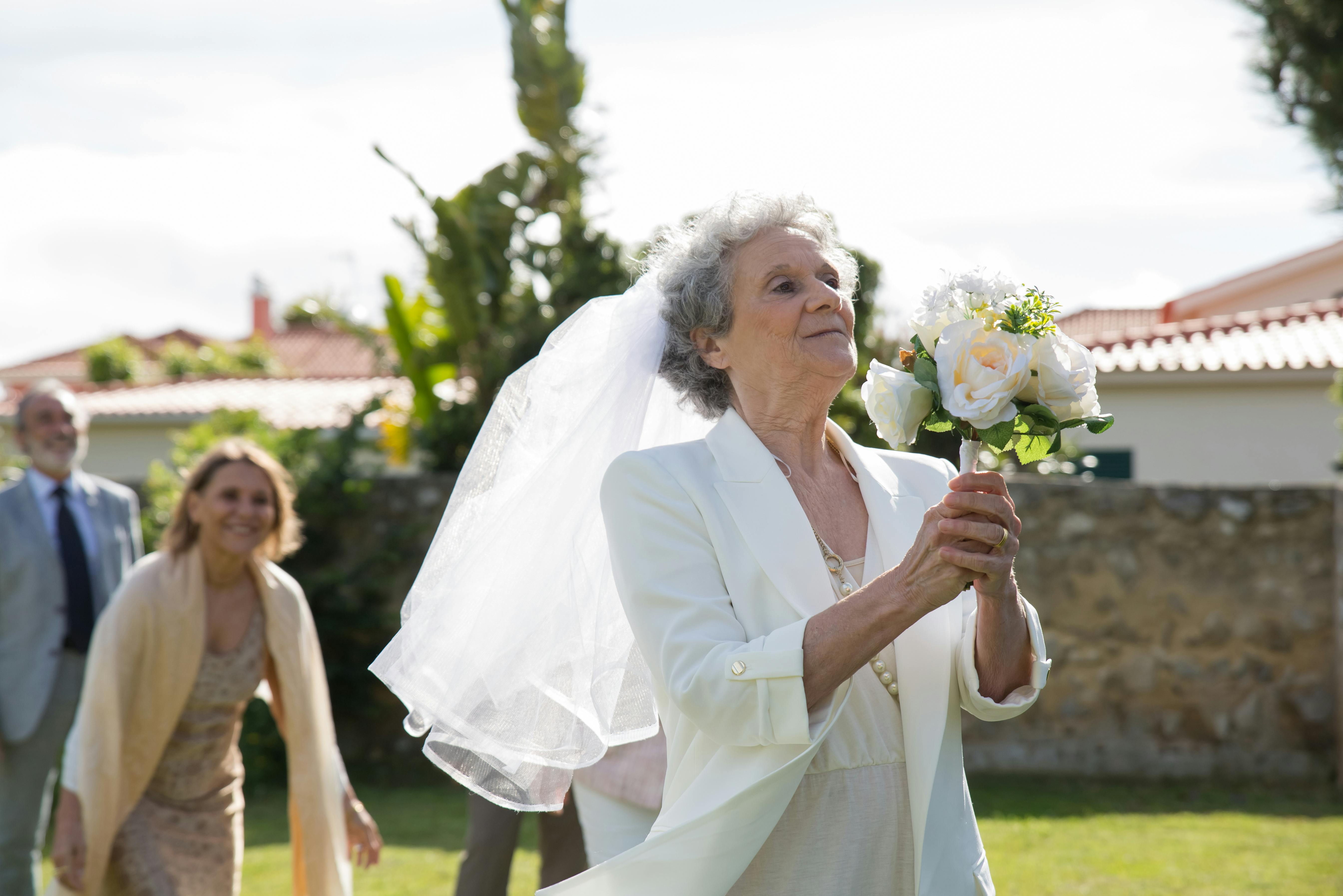 Une femme âgée prête à lancer son bouquet de mariée | Source : Amomama