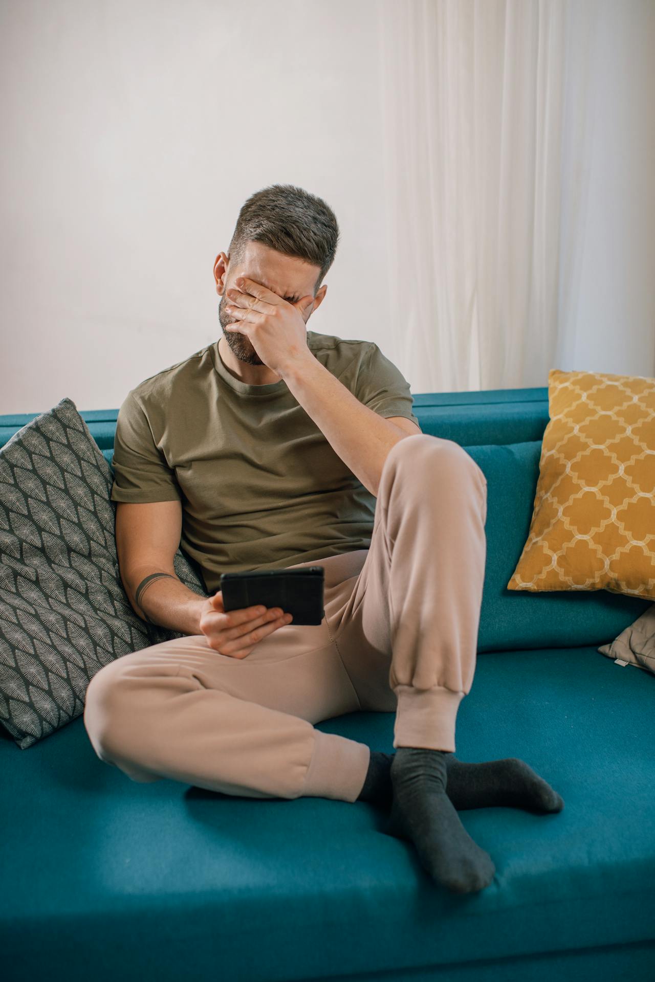 Un homme agacé assis sur le canapé | Source : Pexels