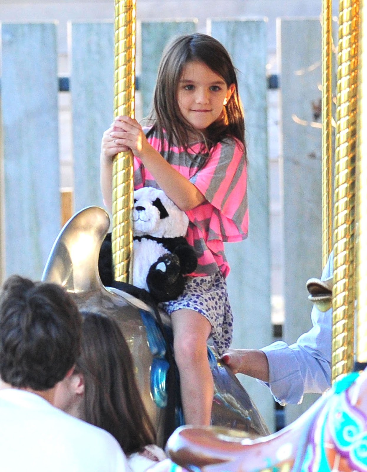 Le 8 octobre 2011, Suri s'est amusée à faire un tour sur le carrousel de Schenley Plaza à Pittsburgh, en Pennsylvanie, tenant à ses côtés un panda en peluche qu'elle chérit. Ce moment a capturé une rare journée d'insouciance avec ses parents avant leur séparation. | Source : Getty Images