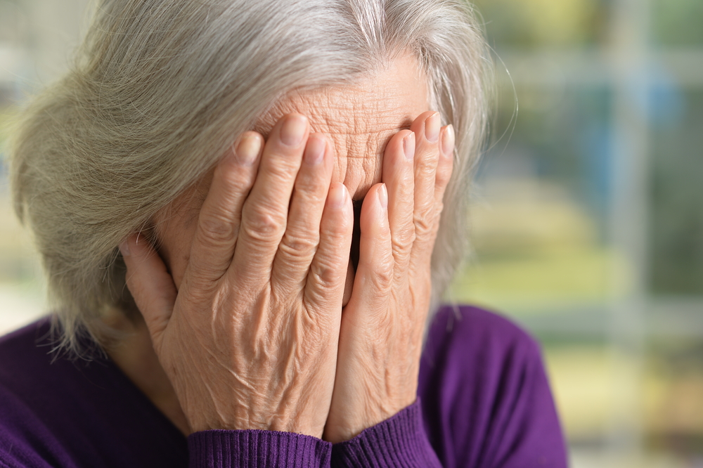 Une femme se couvrant le visage en pleurant | Source : Shutterstock