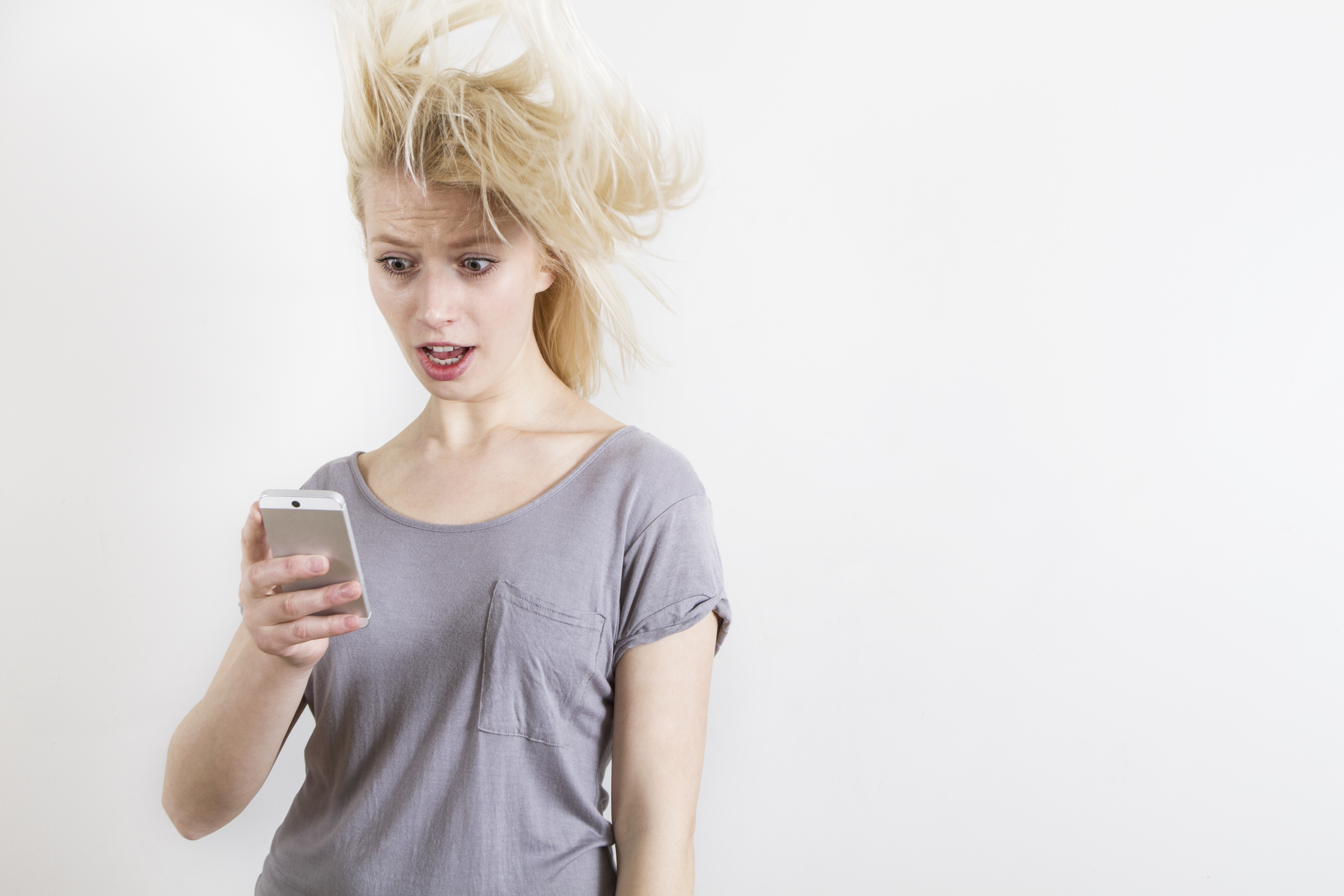 Femme à l'expression choquée regardant son téléphone | Source : Getty Images