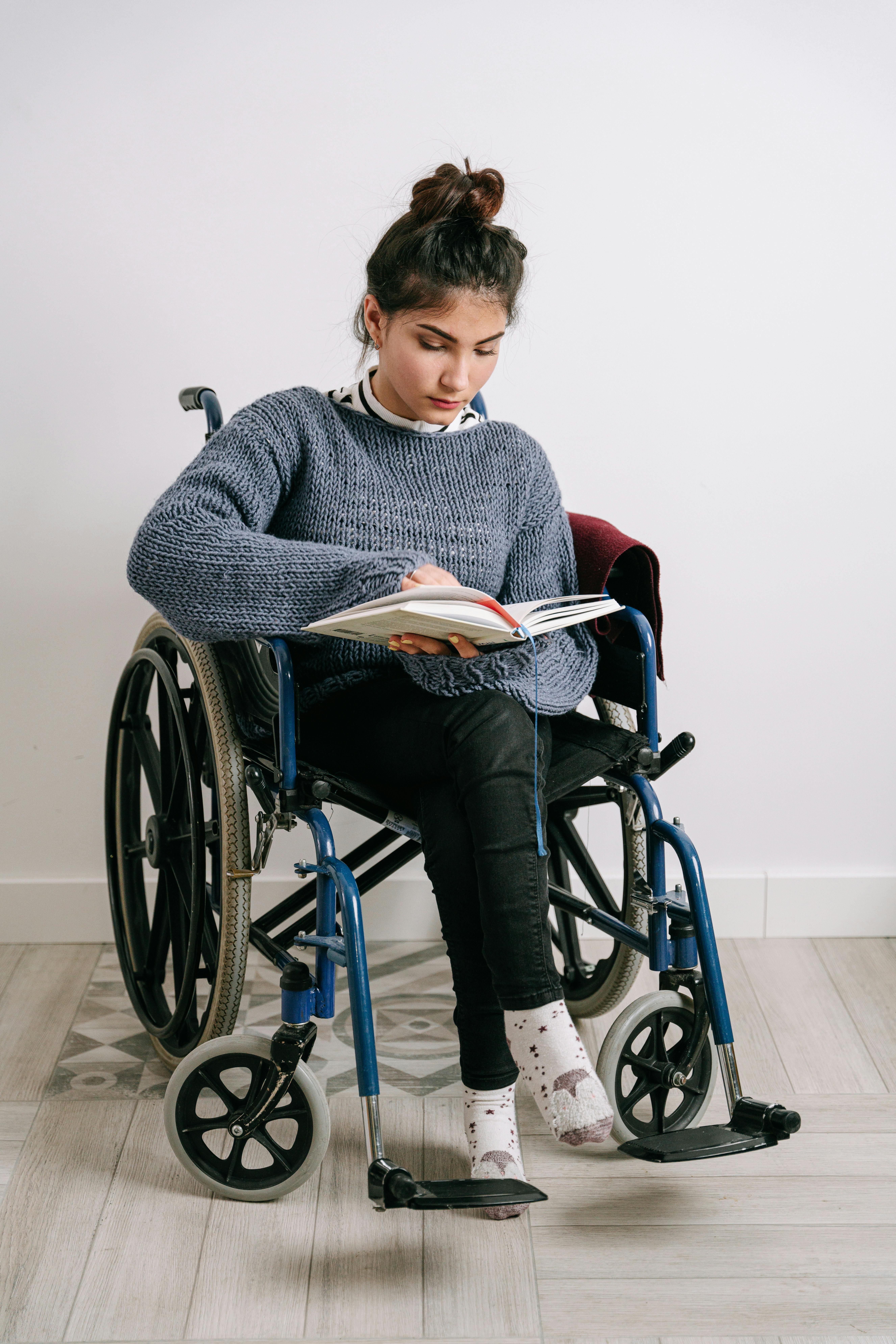 Une jeune femme en fauteuil roulant en train de lire. À des fins d'illustration uniquement | Source : Pexels