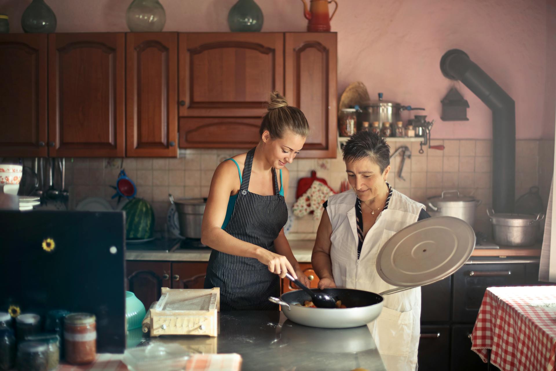 Une jeune femme et sa mère en train de préparer des plats | Source : Pexels