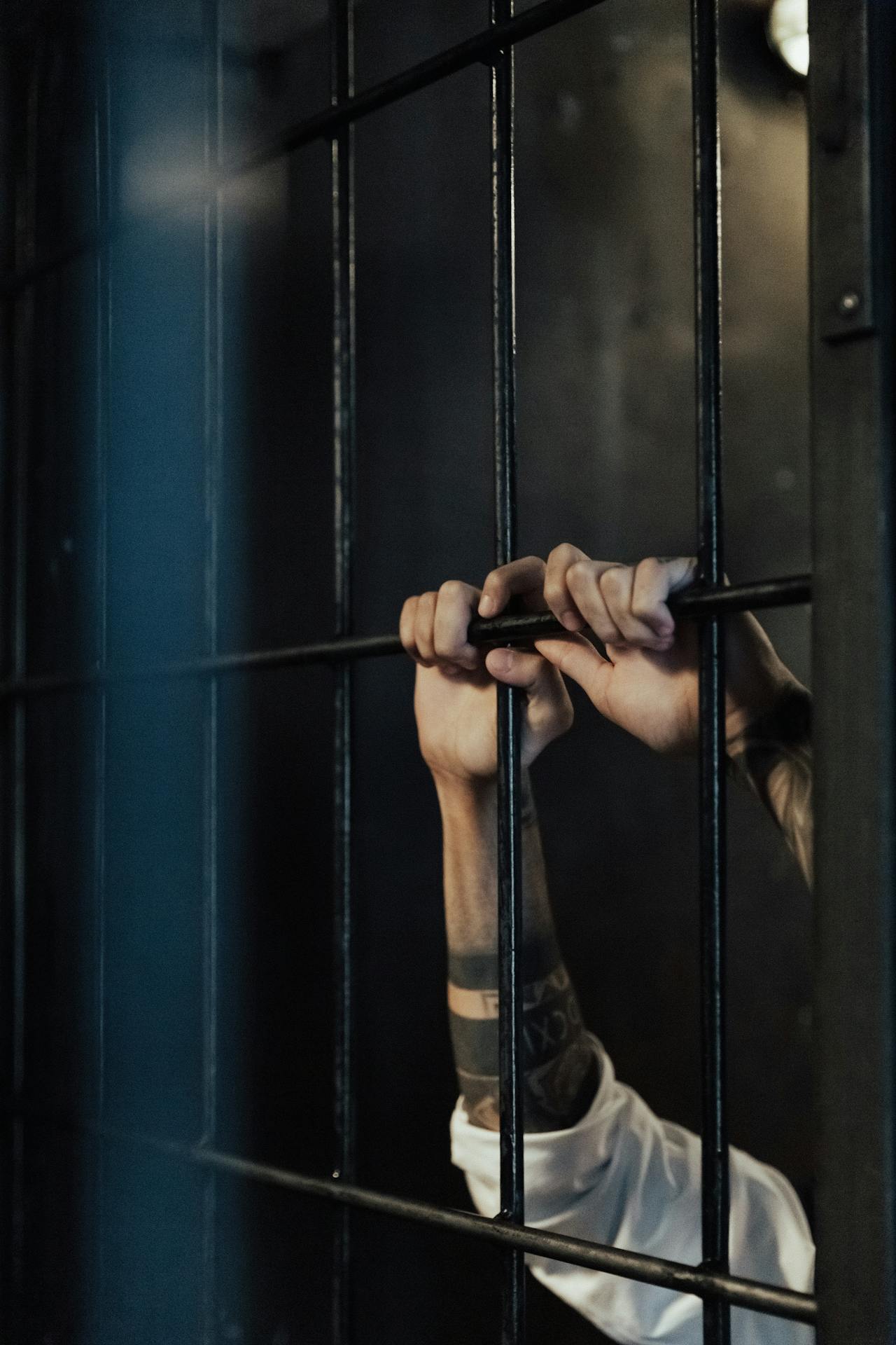 Un prisonnier tenant des grilles métalliques dans une prison | Source : Pexels