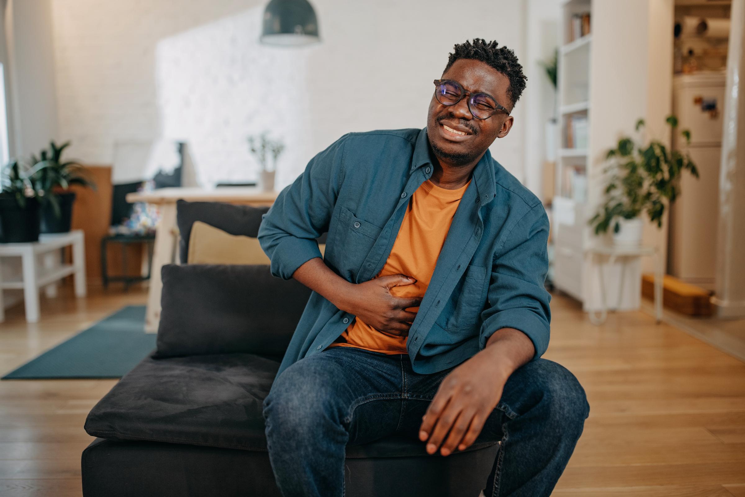 Jeune homme se touchant la poitrine, semblant éprouver de l'inconfort ou de la douleur | Source : Getty Images