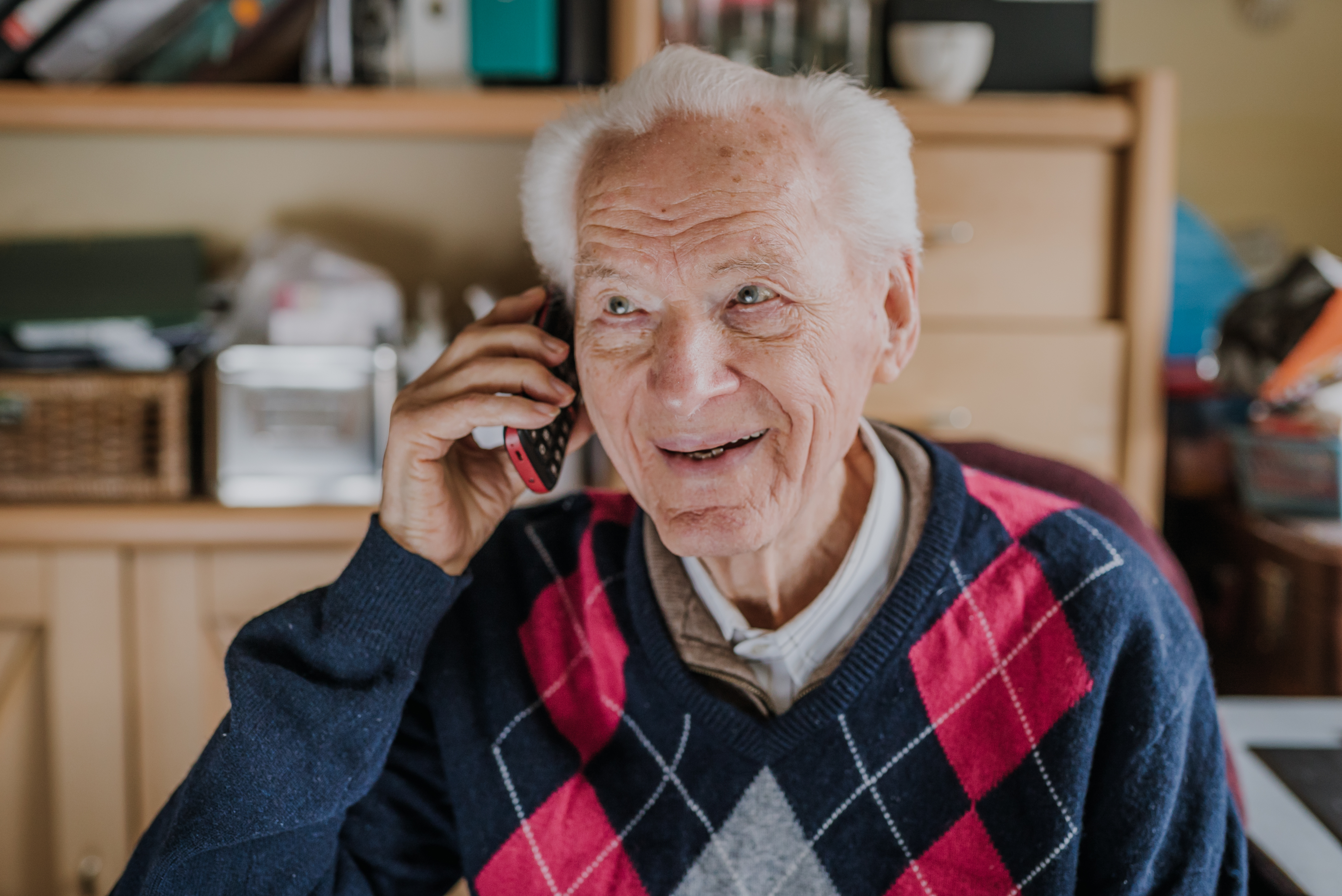 Un homme souriant tout en parlant au téléphone | Source : Getty Images