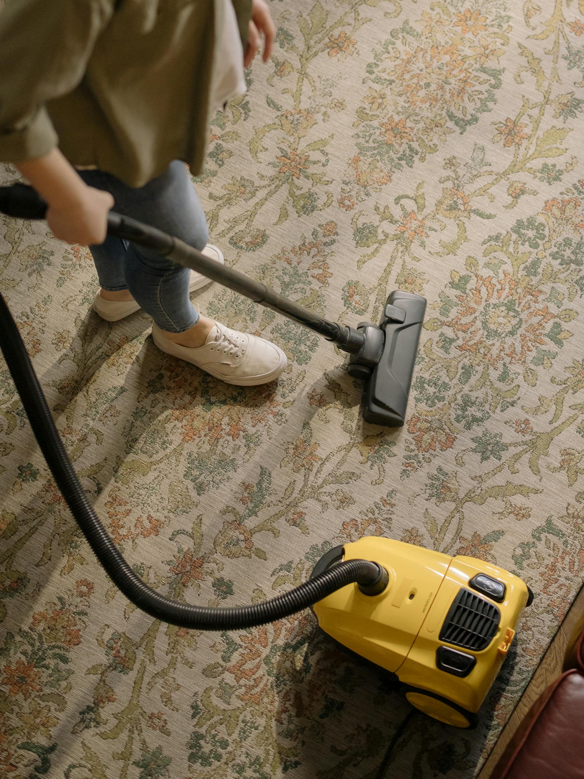 Une femme passe l'aspirateur sur un tapis | Source : Pexels