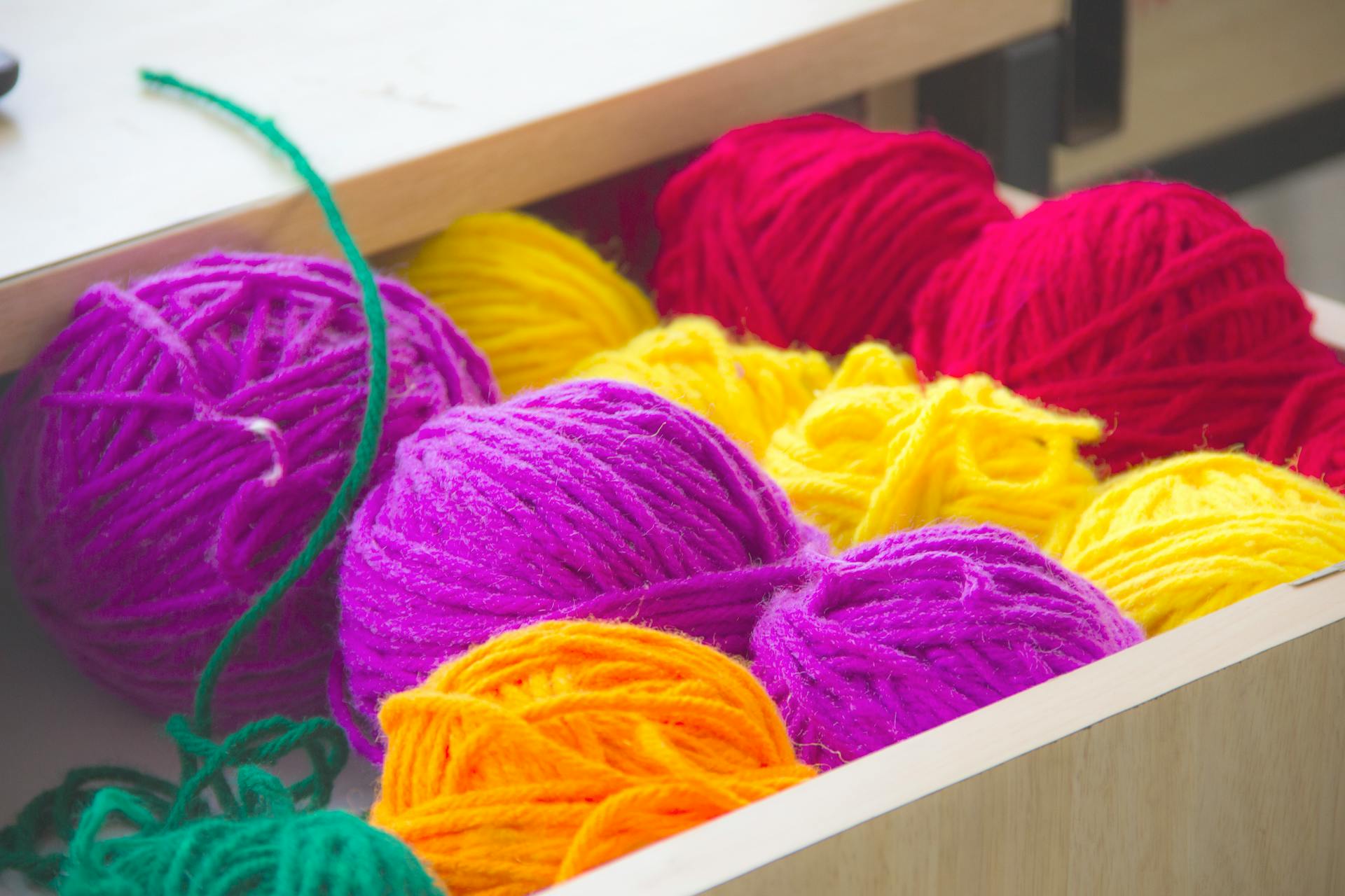 Des pelotes de fil colorées dans un tiroir | Source : Pexels
