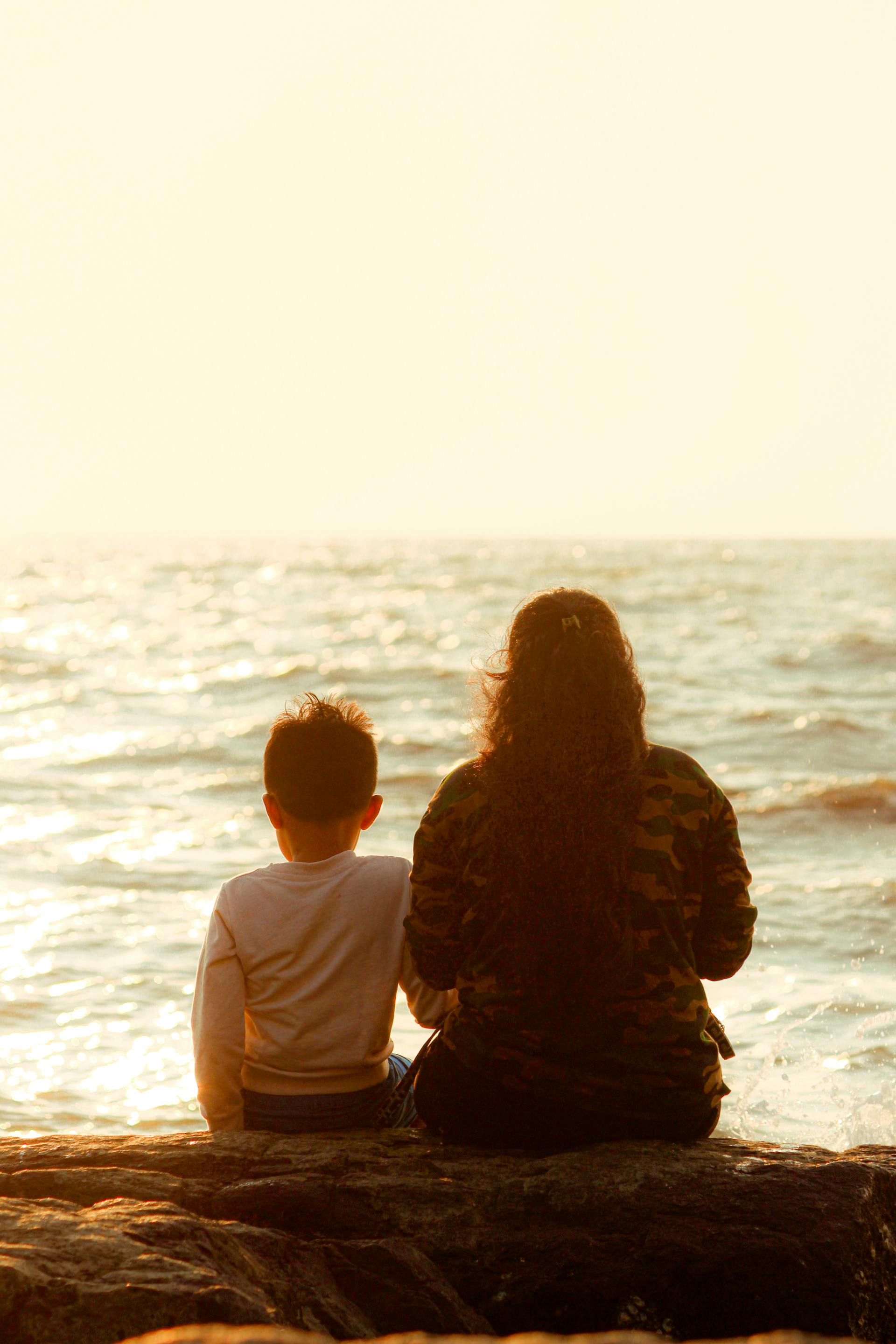 Une mère assise avec son fils au bord de la mer | Source : Pexels