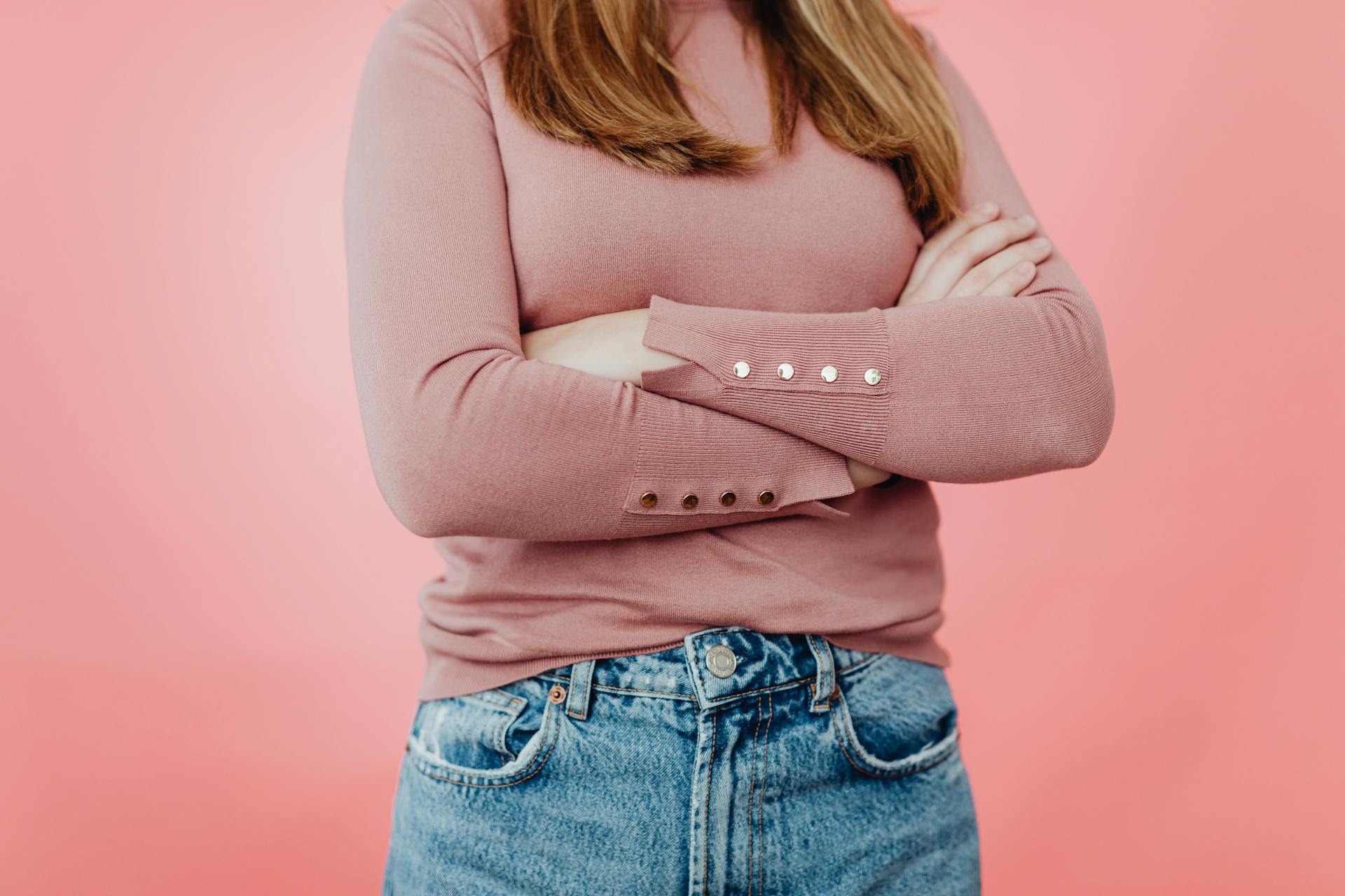 Photo recadrée d'une fille portant un pull rose et un jean bleu | Source : Pexels