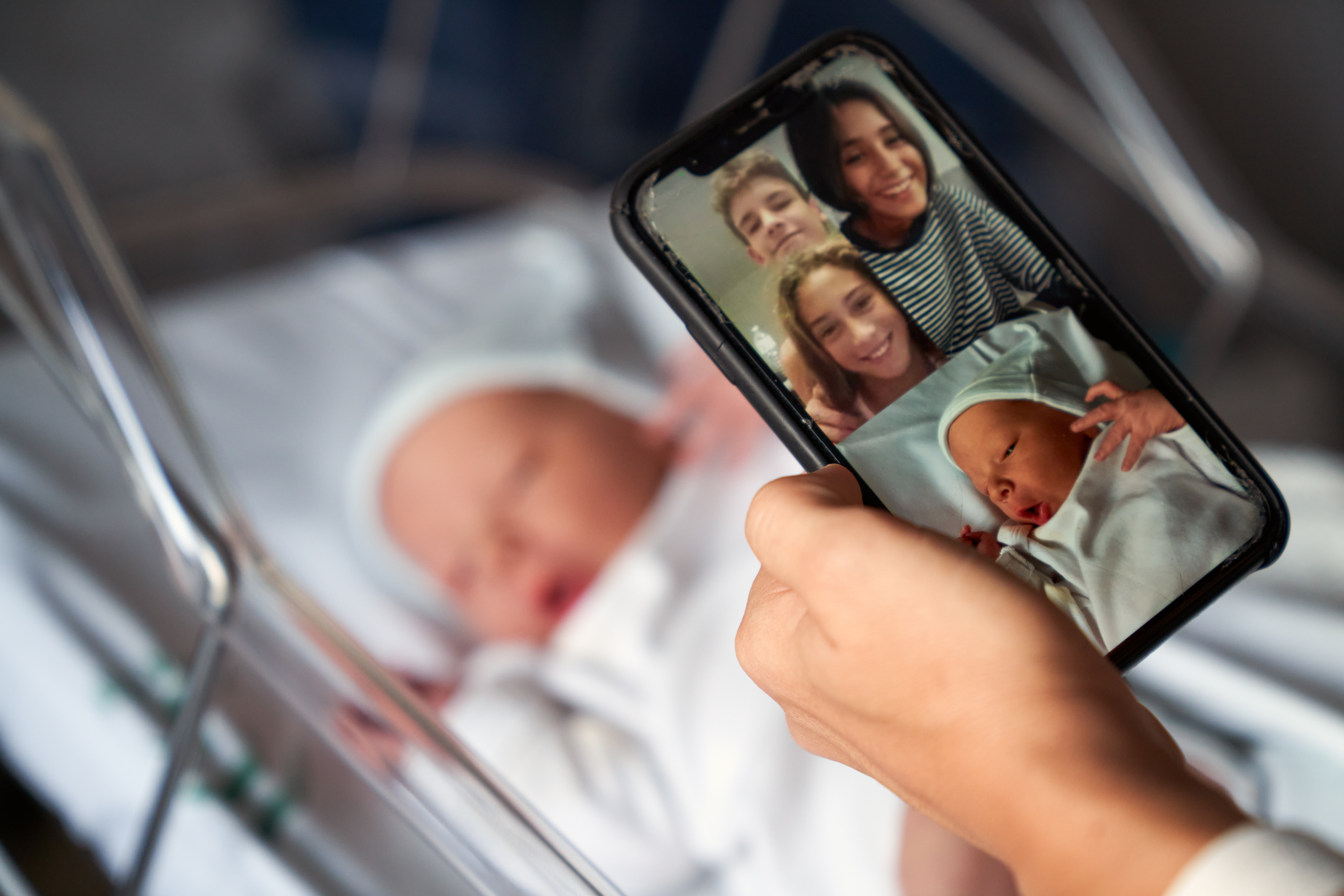 Une femme montre son nouveau-né à sa famille par vidéoconférence | Source : Getty Images