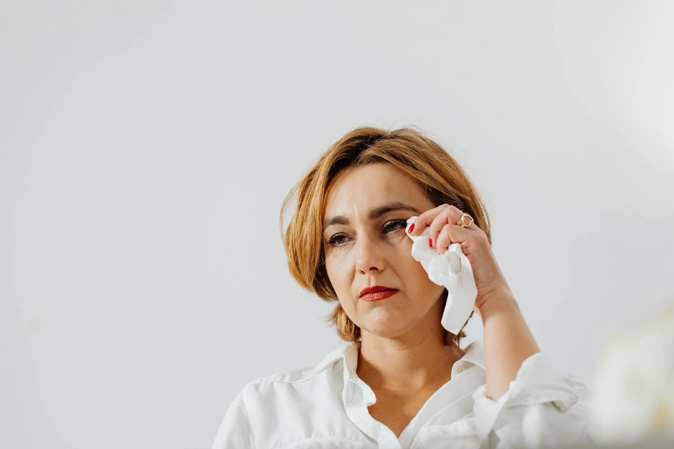 Une femme d'âge moyen s'essuyant les yeux | Source : Pexels