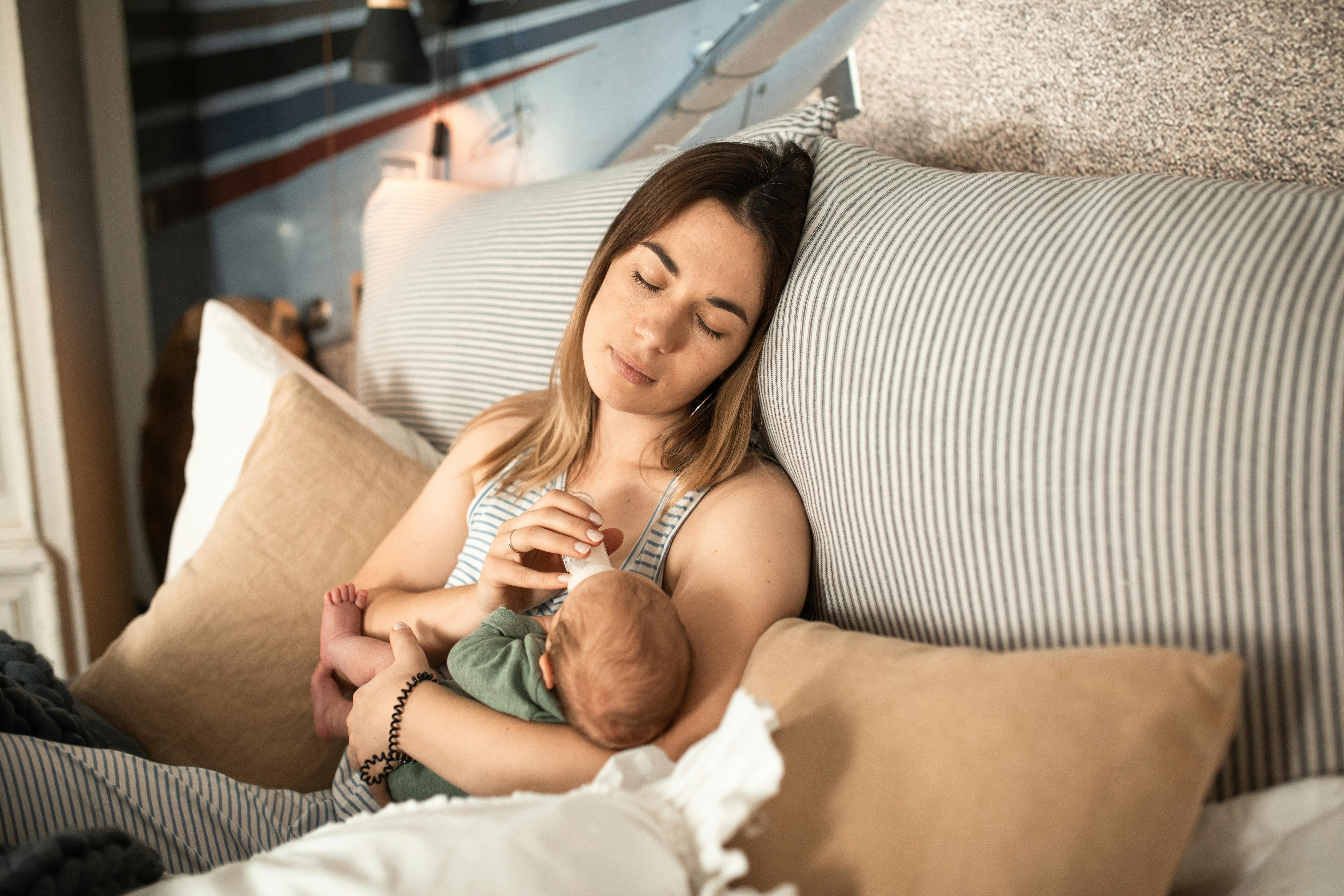 Une femme qui nourrit un bébé dans son lit | Source : Pexels