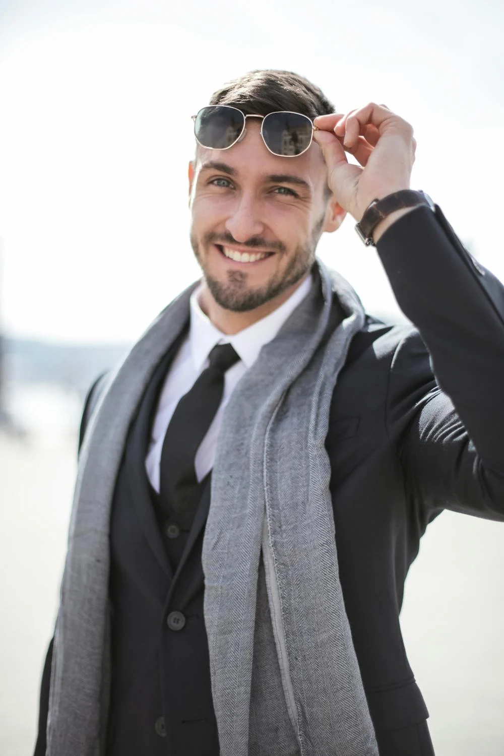 Un homme souriant soulevant ses lunettes de soleil de son visage | Source : Pexels