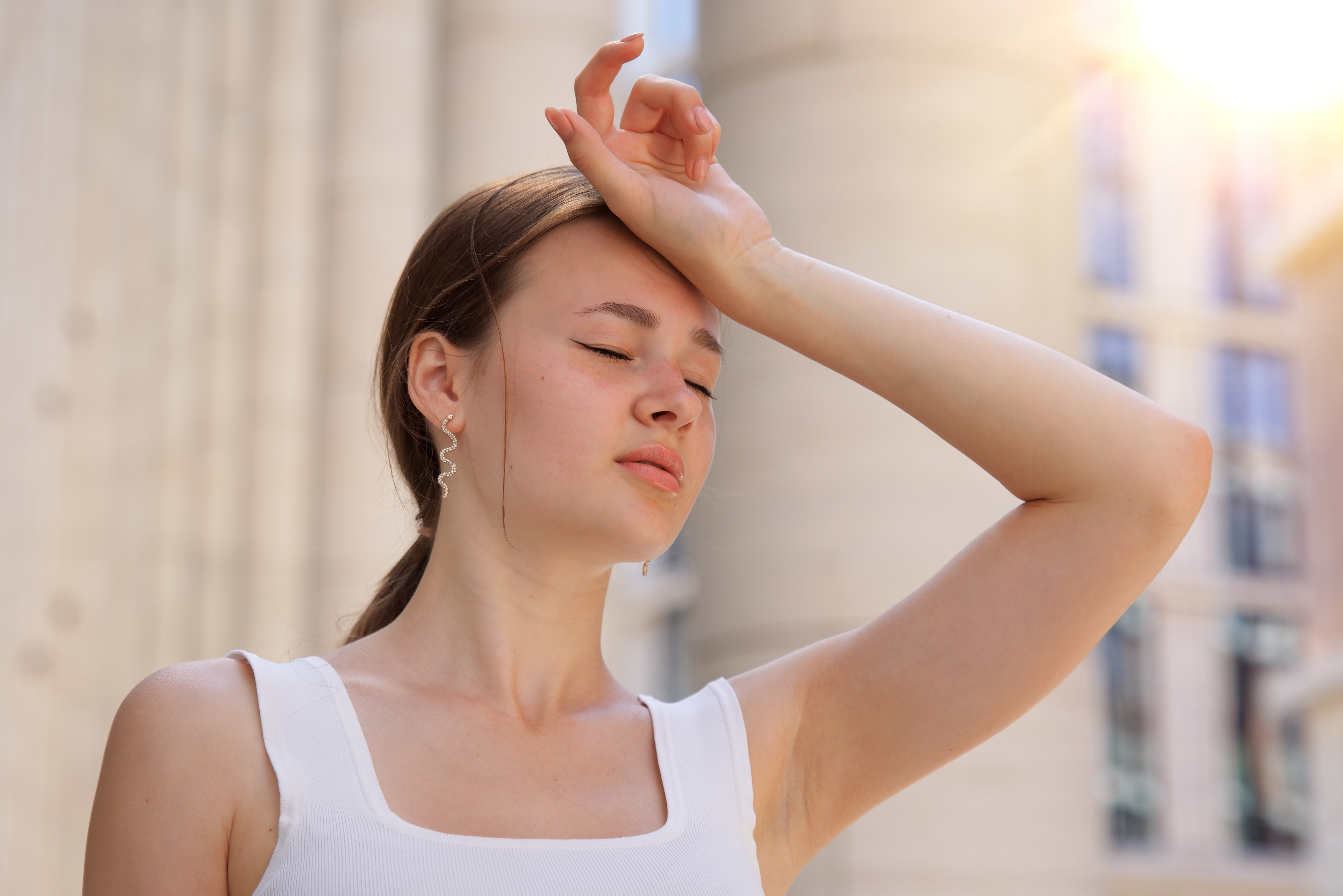 Une jeune fille posant sa main sur sa tête ayant l'air étourdie | Source : Shutterstock