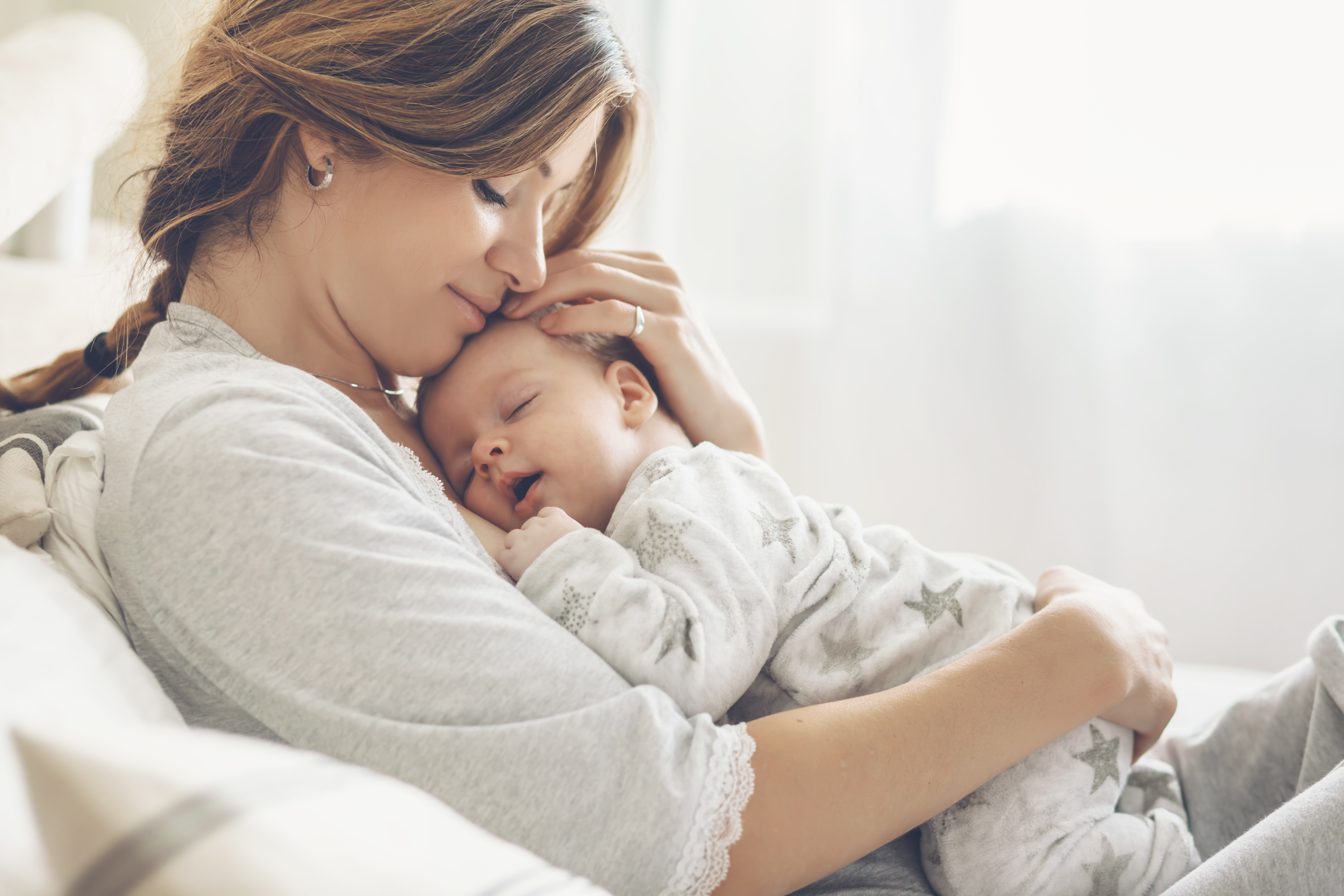 Une femme prend dans ses bras un nouveau-né | Source : Shutterstock
