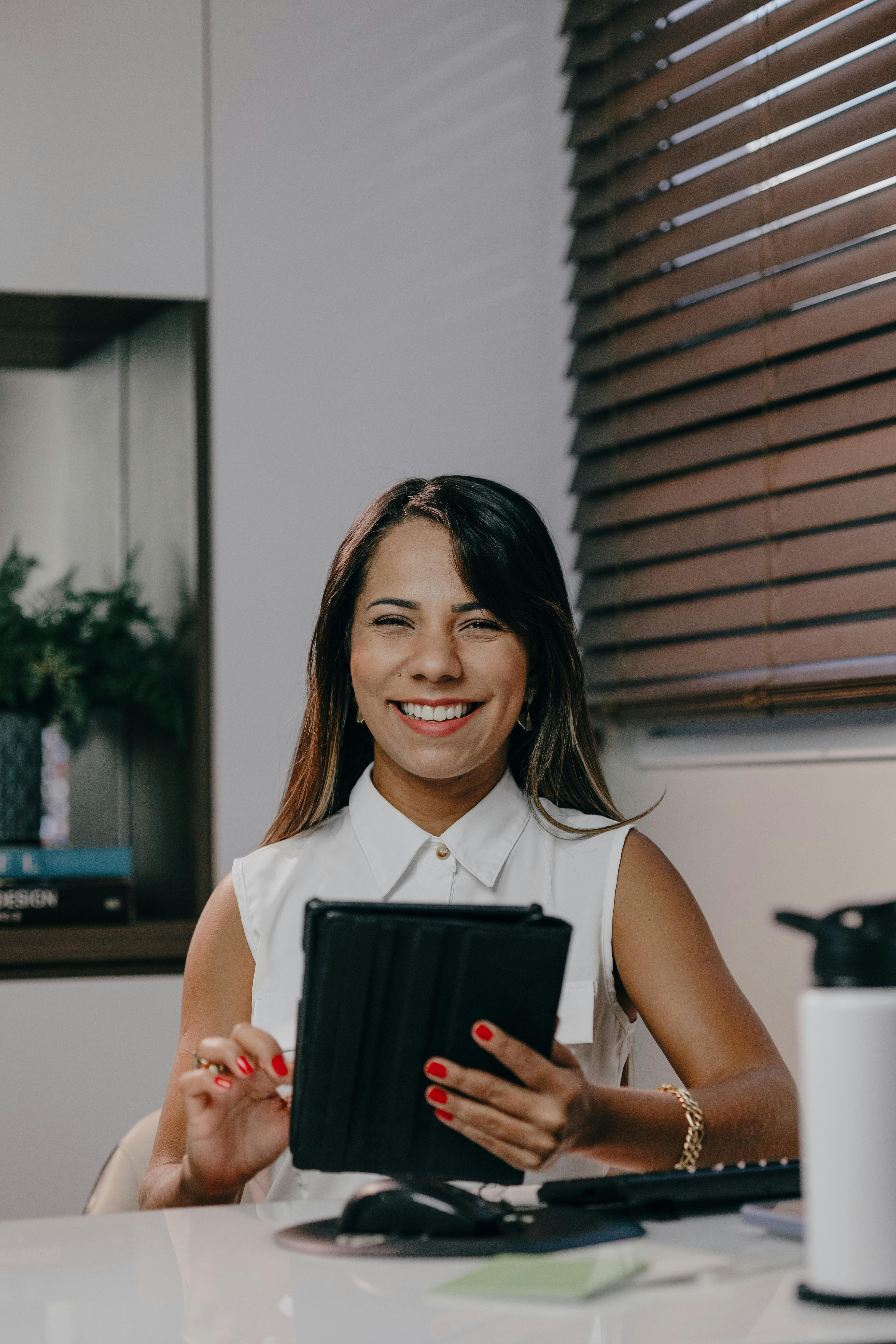 Une femme souriante sur son lieu de travail | Source : Pexels