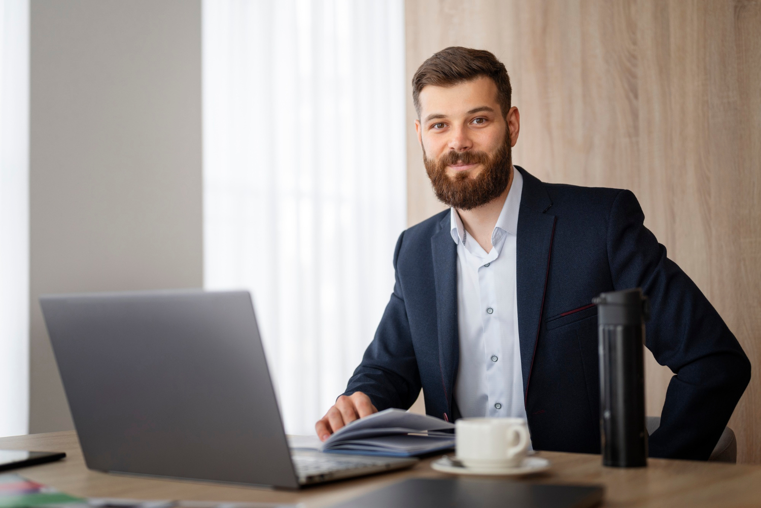 Un élégant homme d'affaires assis dans son bureau | Source : Freepik