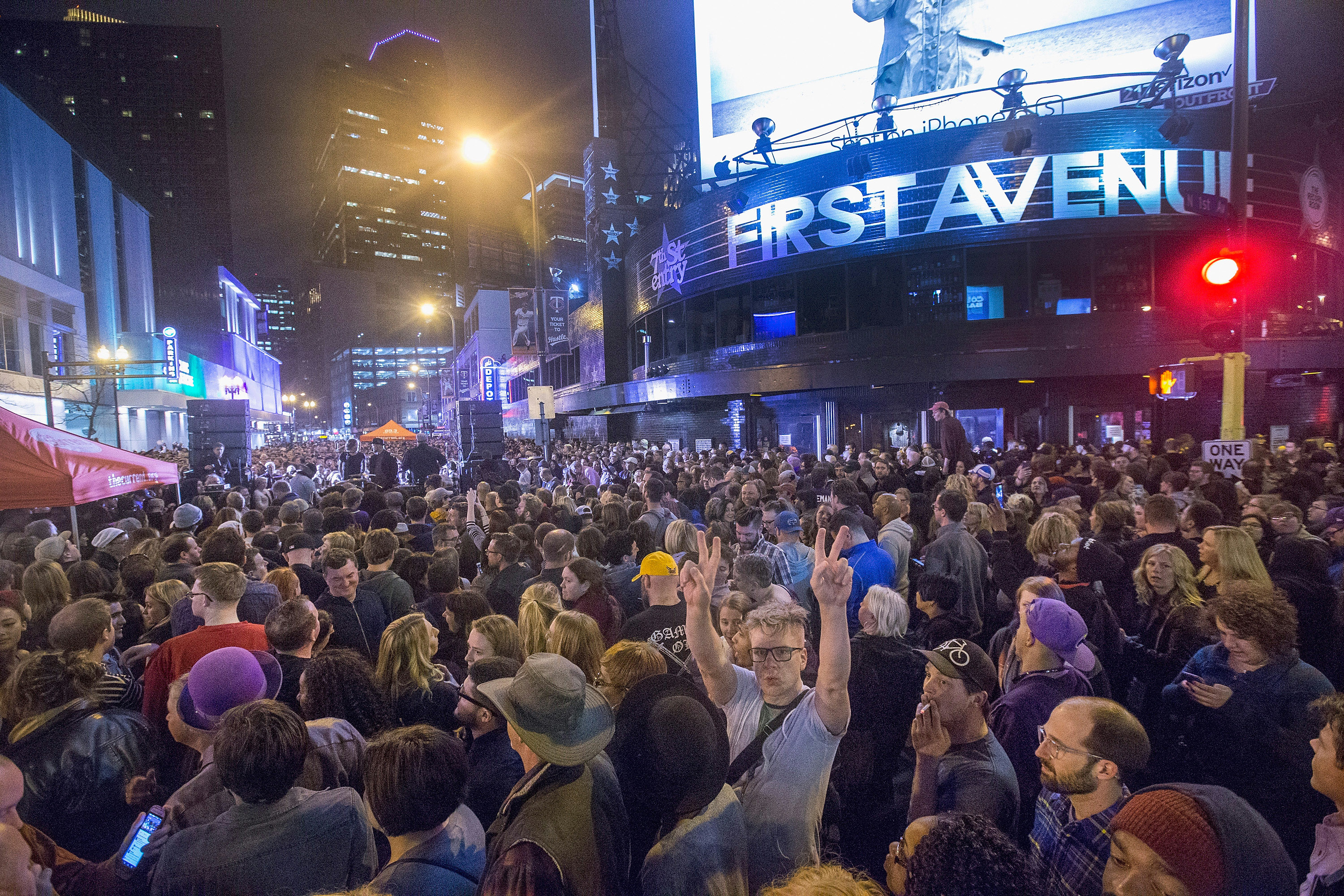 Des fans écoutant la musique de Prince lors d'une fête de rue commémorative à l'extérieur de la boîte de nuit First Avenue à Minneapolis, Minnesota, le 21 avril 2016 | Source : Getty Images