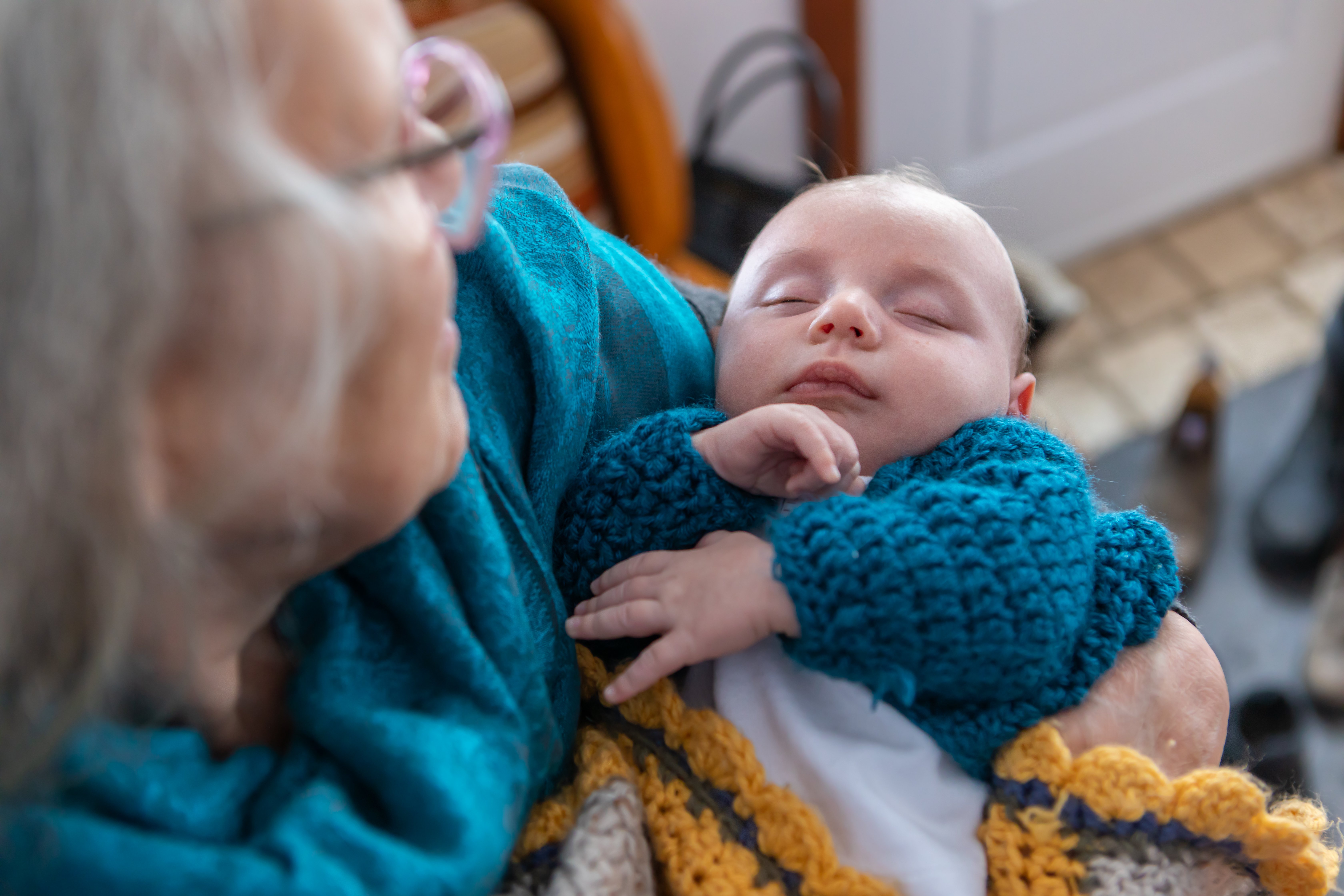 Une femme âgée tient un bébé dans ses bras. | Source : Shutterstock