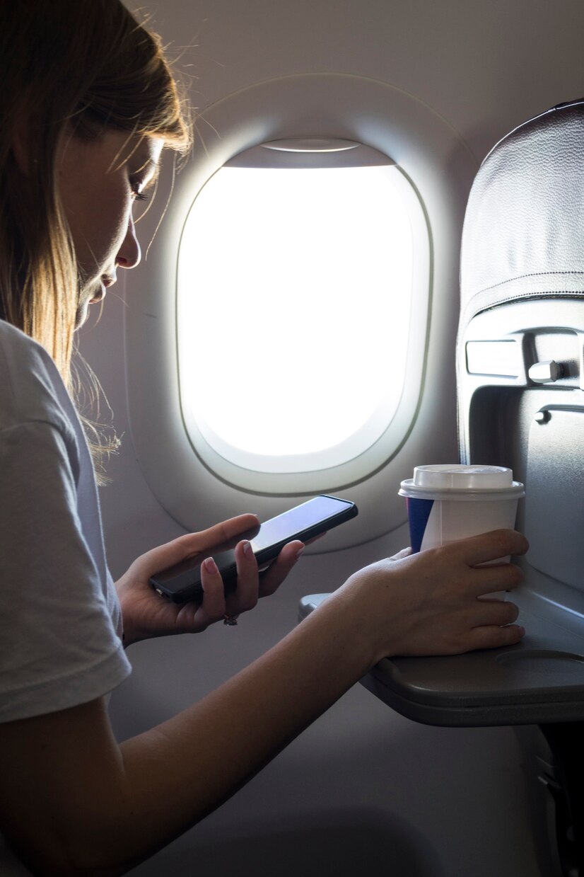 Une femme qui regarde son téléphone dans un avion | Source : Pexels