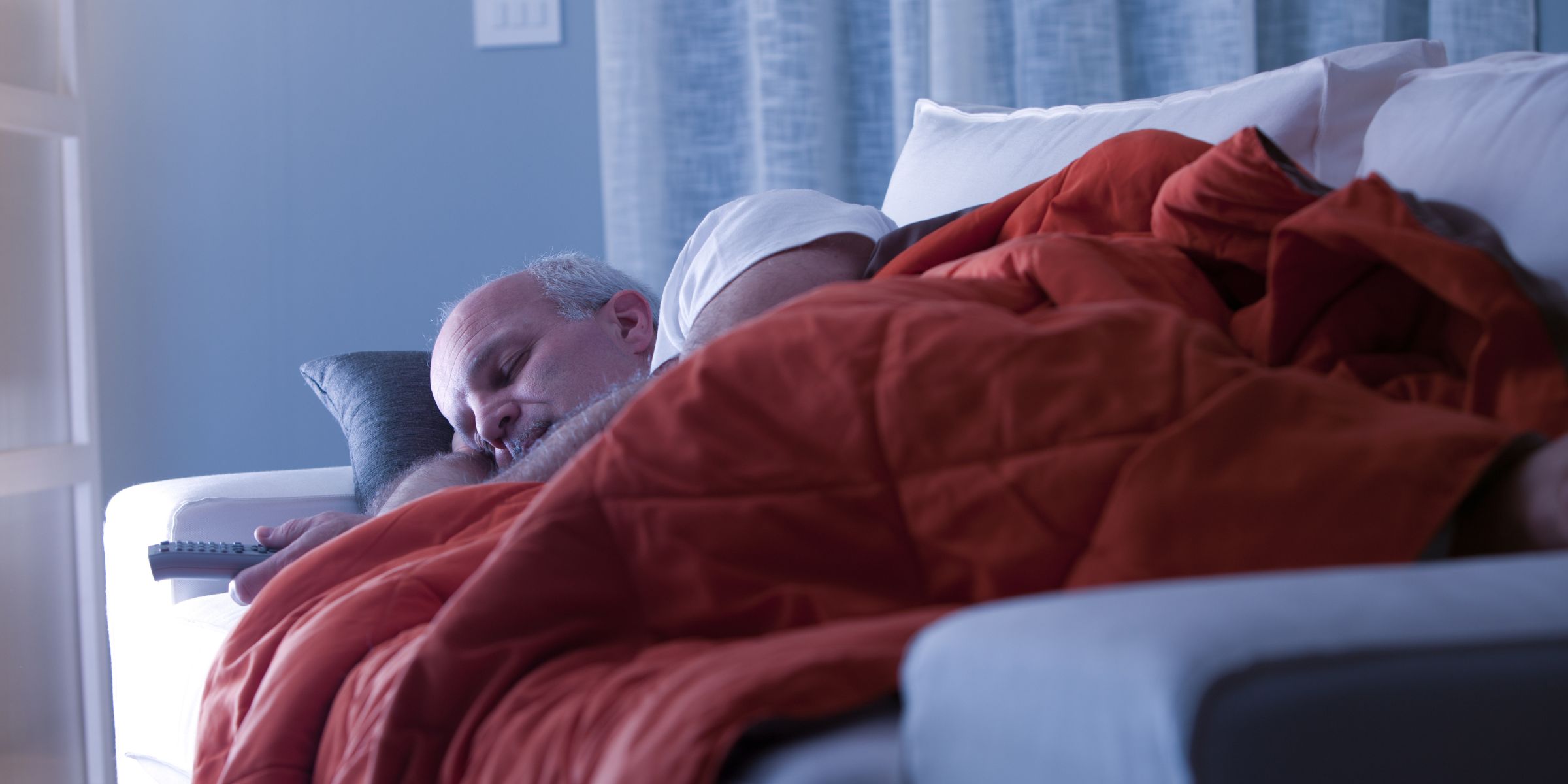Un homme qui dort sur un canapé | Source : Shutterstock