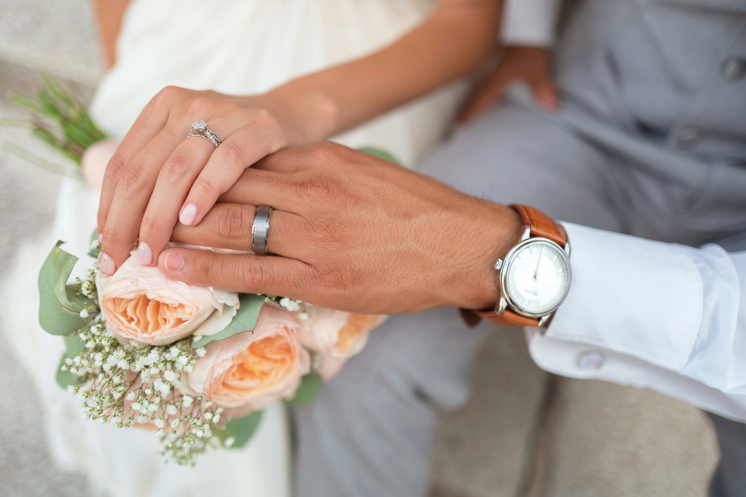 Un couple touche un bouquet lors de son grand jour | Source : Unsplash