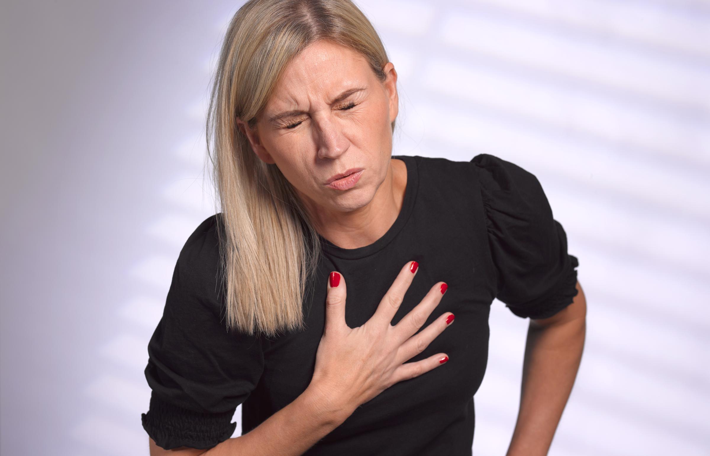 Une femme se serre la poitrine en signe de douleur | Source : Getty Images