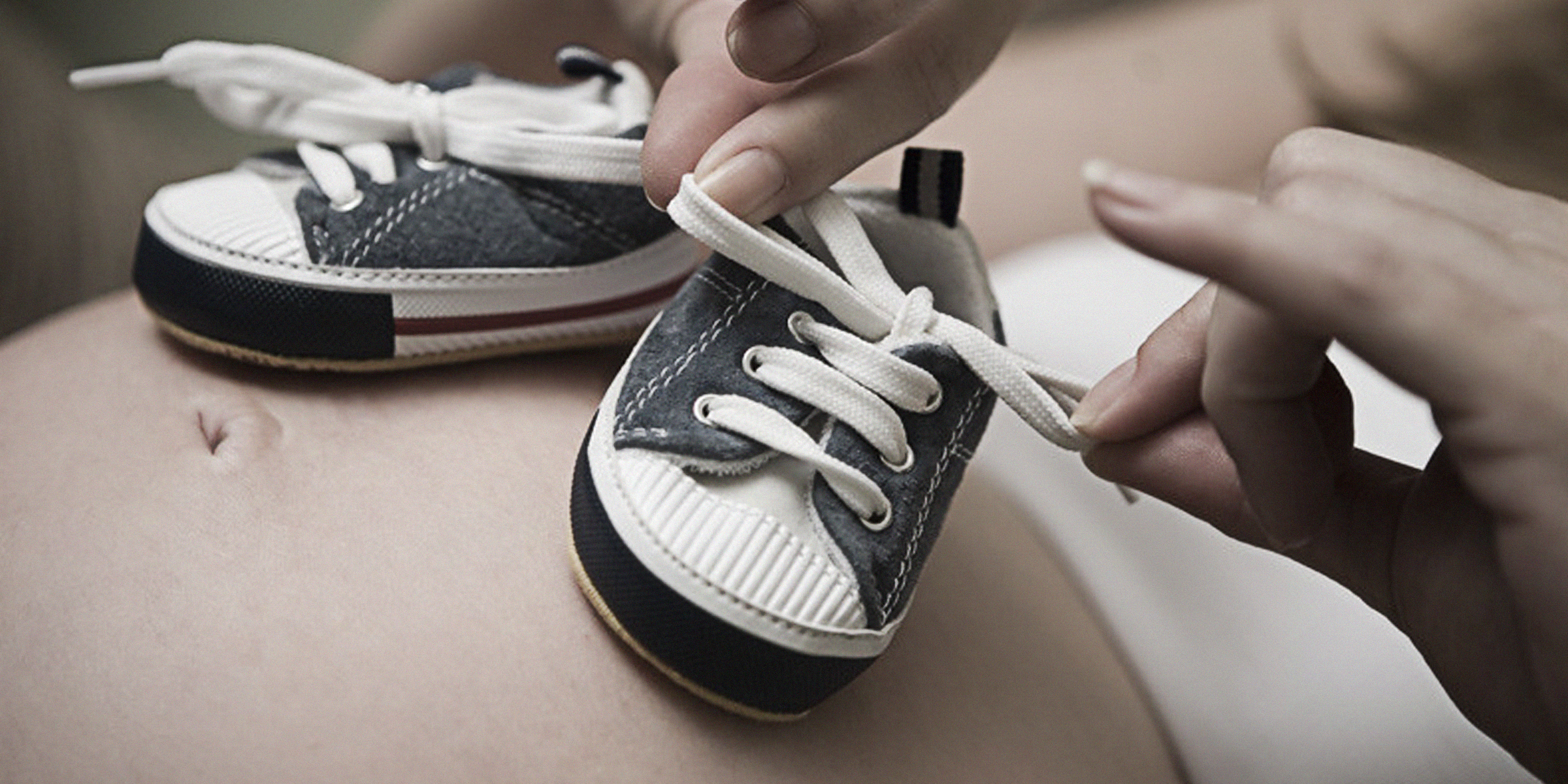 Chaussures de bébé posées sur le ventre d'une femme enceinte | Source : flickr.com/Ⅿeagan/CC BY 2.0