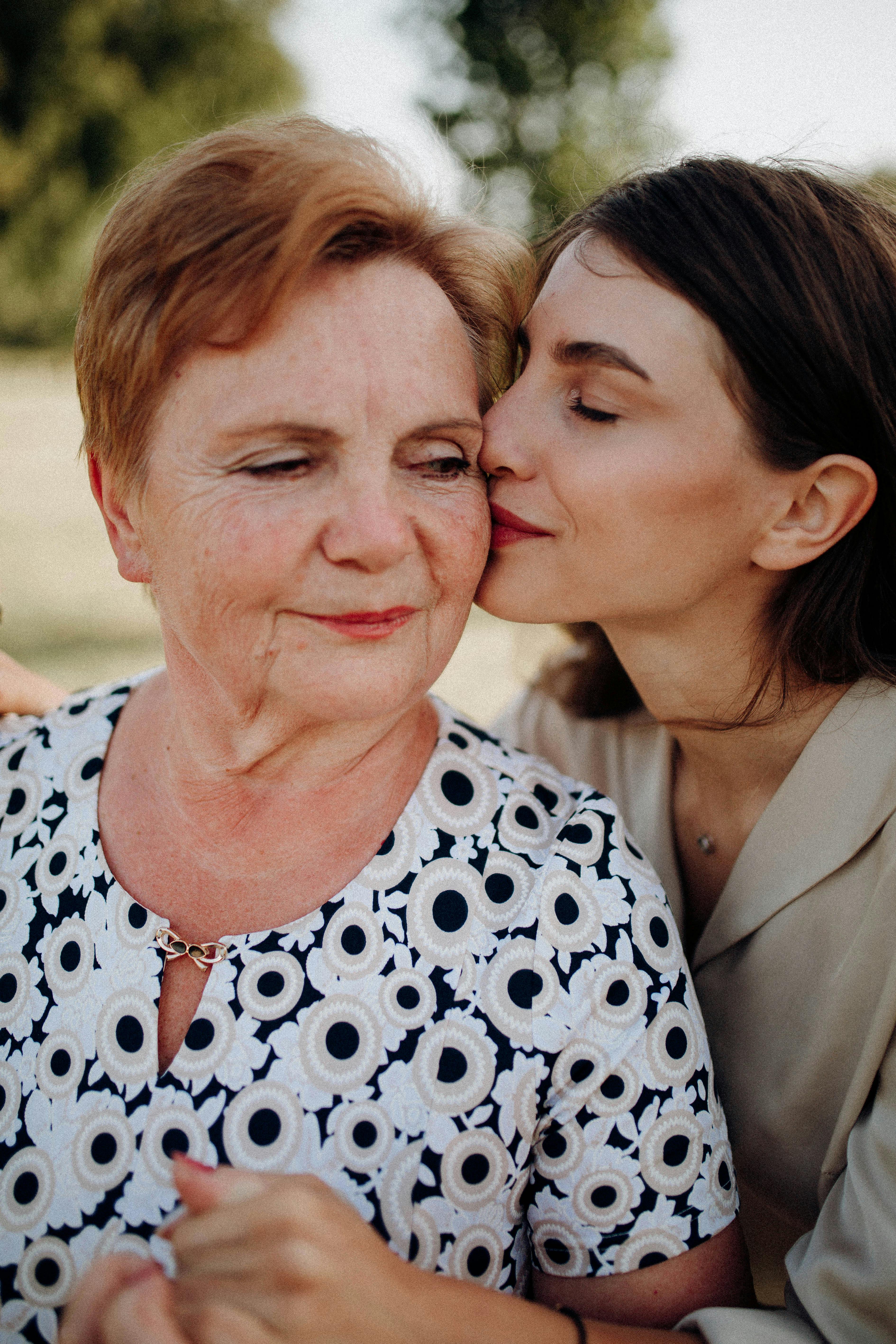 Une jeune femme embrassant une femme plus âgée sur la joue | Source : Pexels