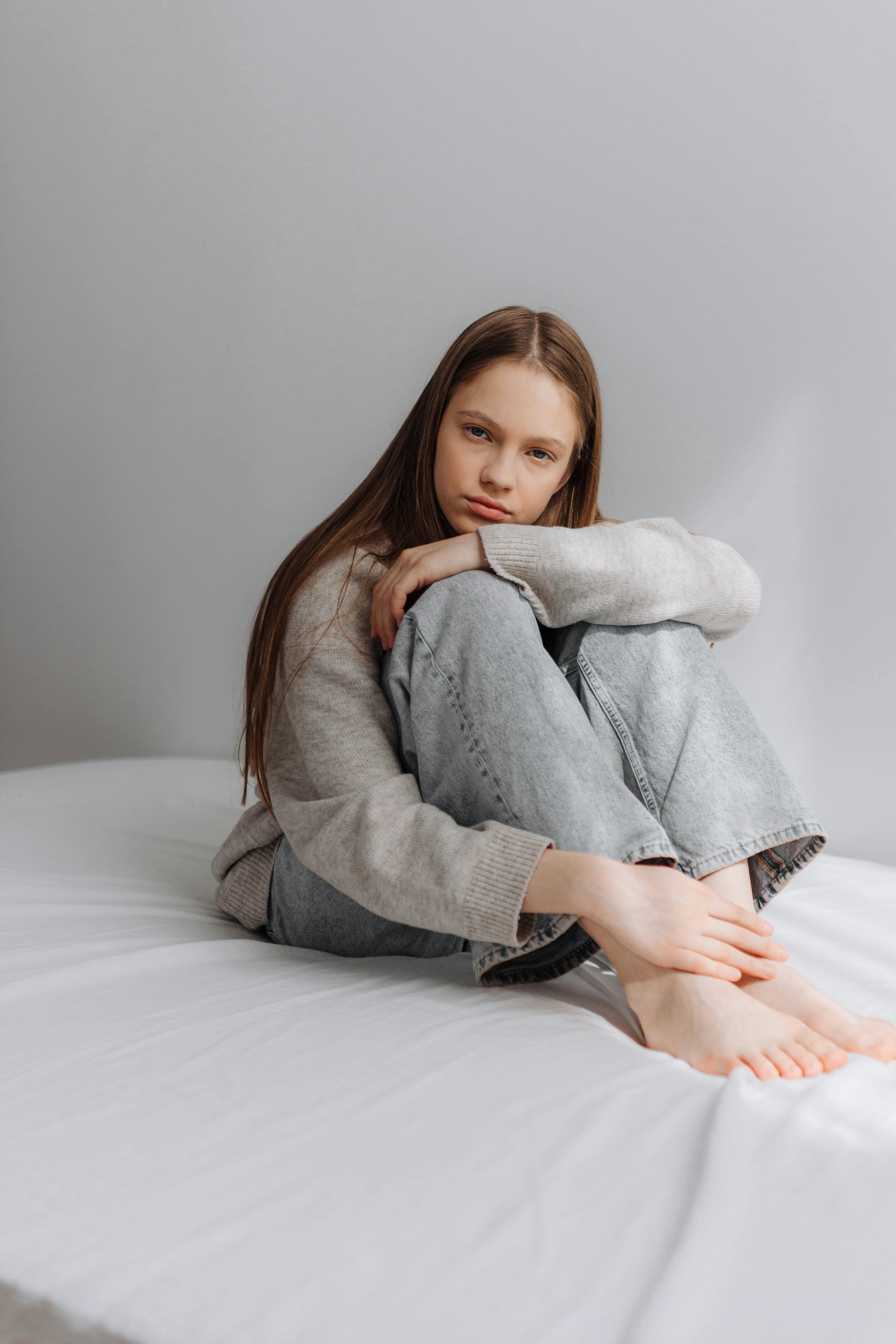 Une jeune fille assise sur un lit | Source : Pexels