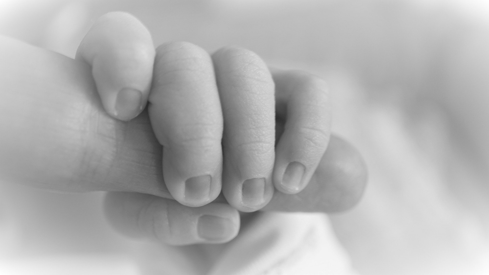 Un nouveau né tenant un doigt | Photo : Pixabay.